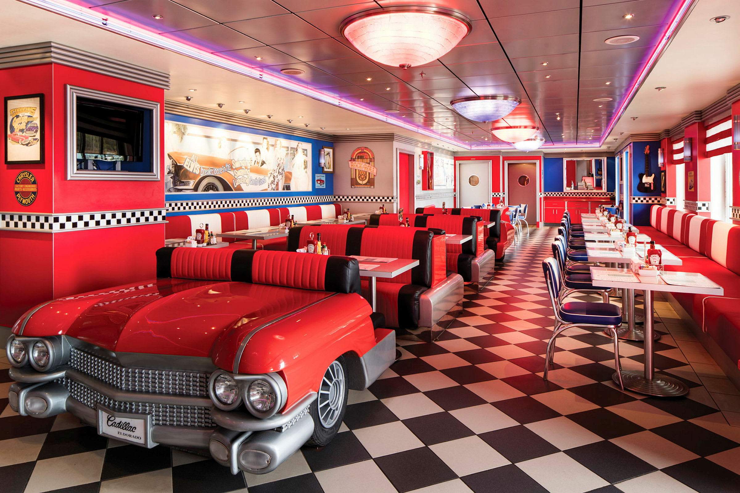 Interiør av en amerikansk diner med røde møbler og bil-inspirerte sitteplasser. (AI-generert tekst)