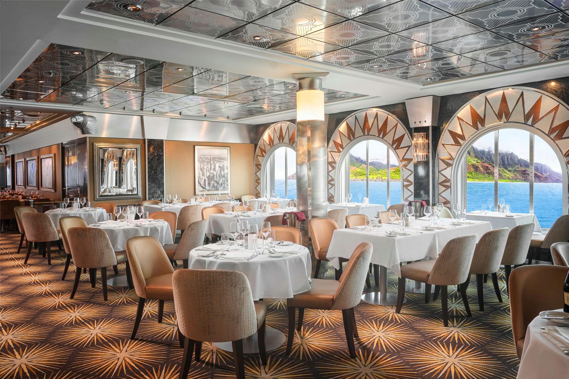 En restaurant med hvite duker og store vinduer med utsikt over sjøen og en grønn kyst. (AI-generert tekst)
