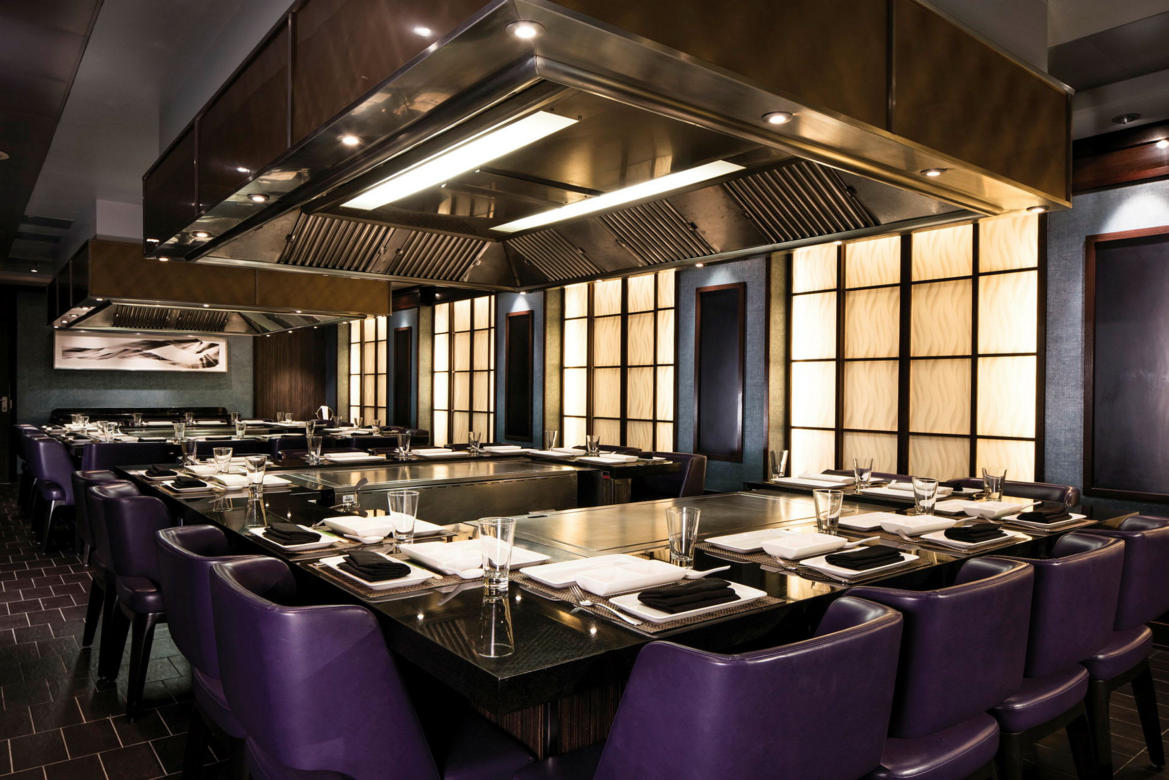 En elegant restaurant med lilla stoler og et moderne kjøkkeninteriør. (AI-generert tekst)