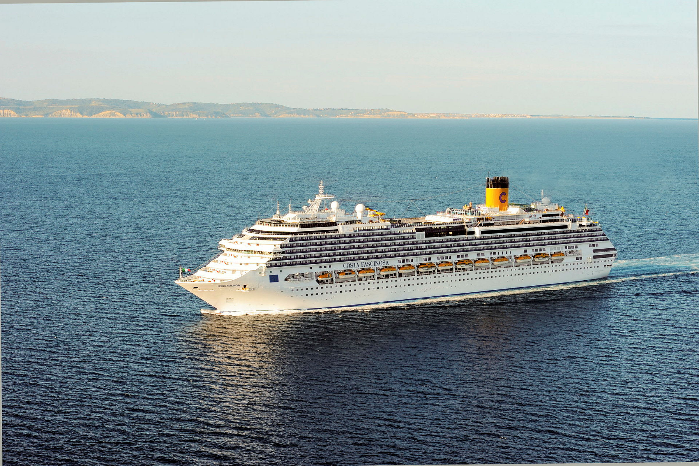 Et stort cruiseskip på havet, med land i bakgrunnen. (AI-generert tekst)
