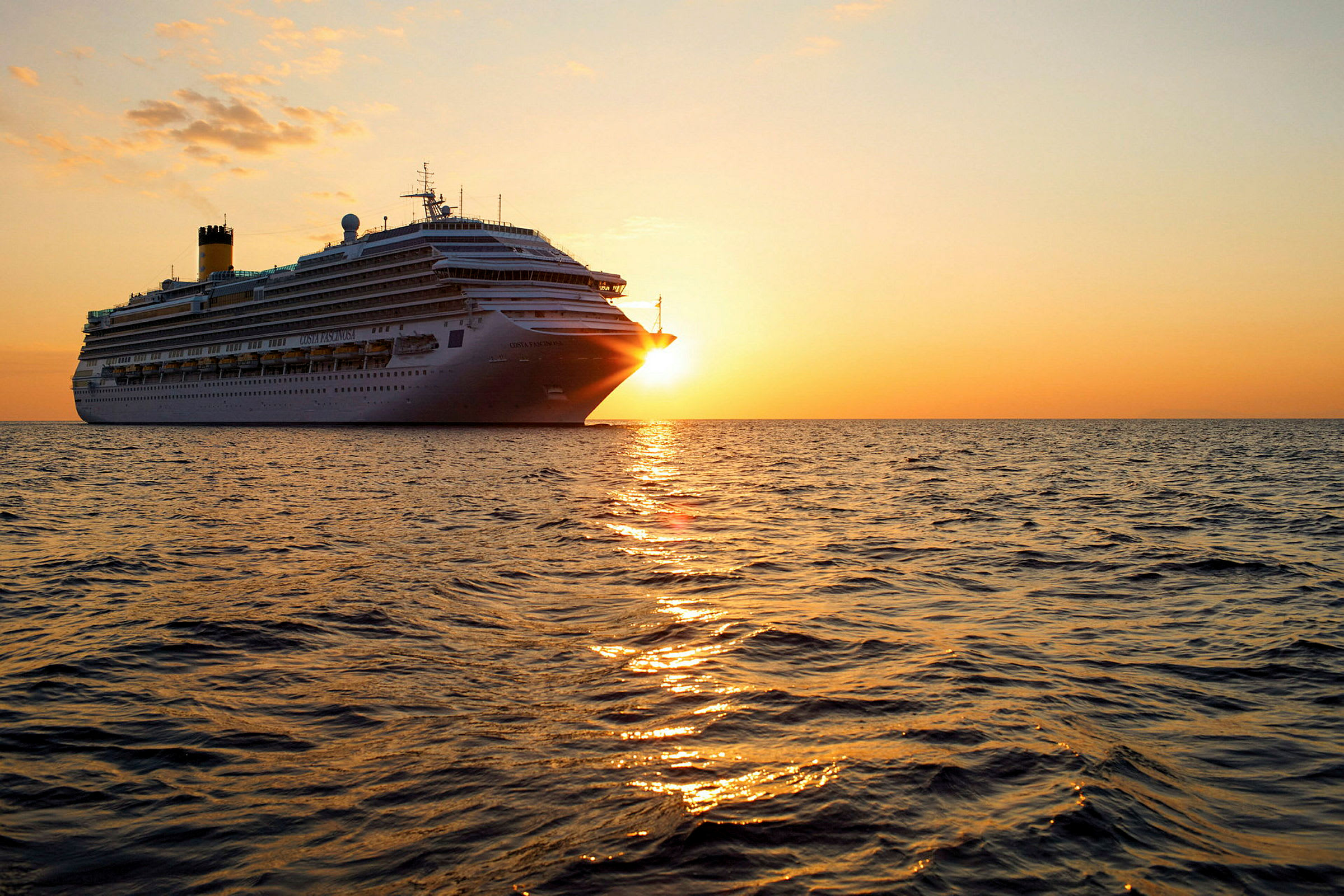 Et cruiseskip seiler på havet under solnedgang. (AI-generert tekst)