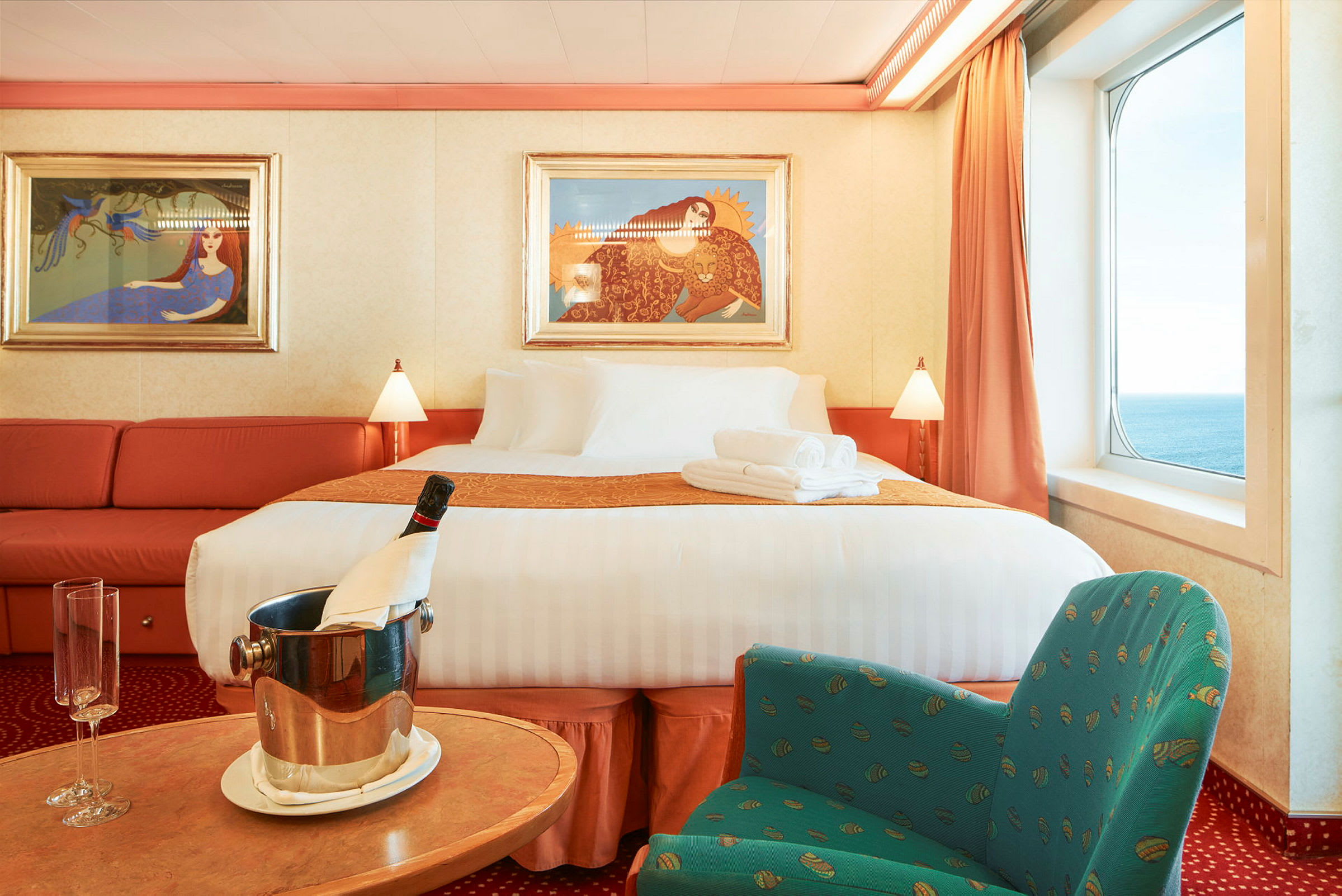 En luksuriøs hotellsuite med stor seng, sittegruppe og havutsikt. (AI-generert tekst)