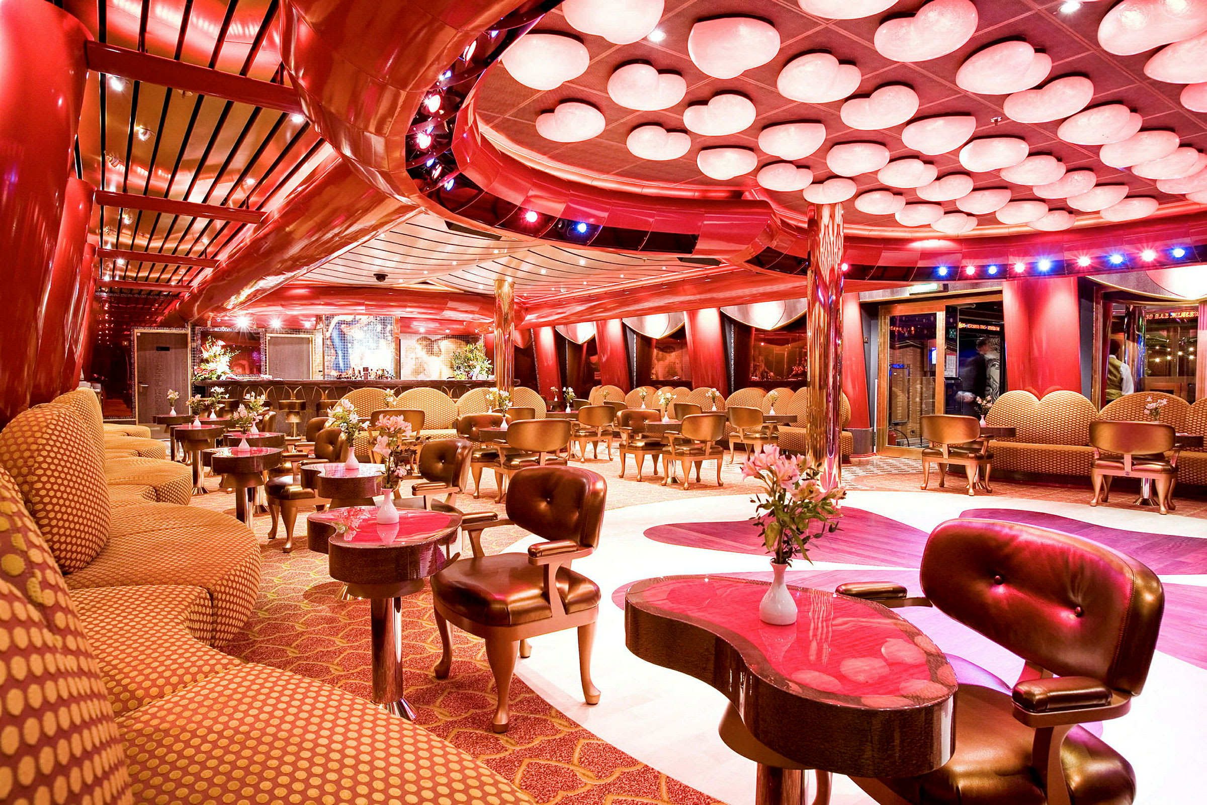 En elegant lounge med røde og gulldetaljer, moderne innredning og blomsterdekorasjoner. (AI-generert tekst)