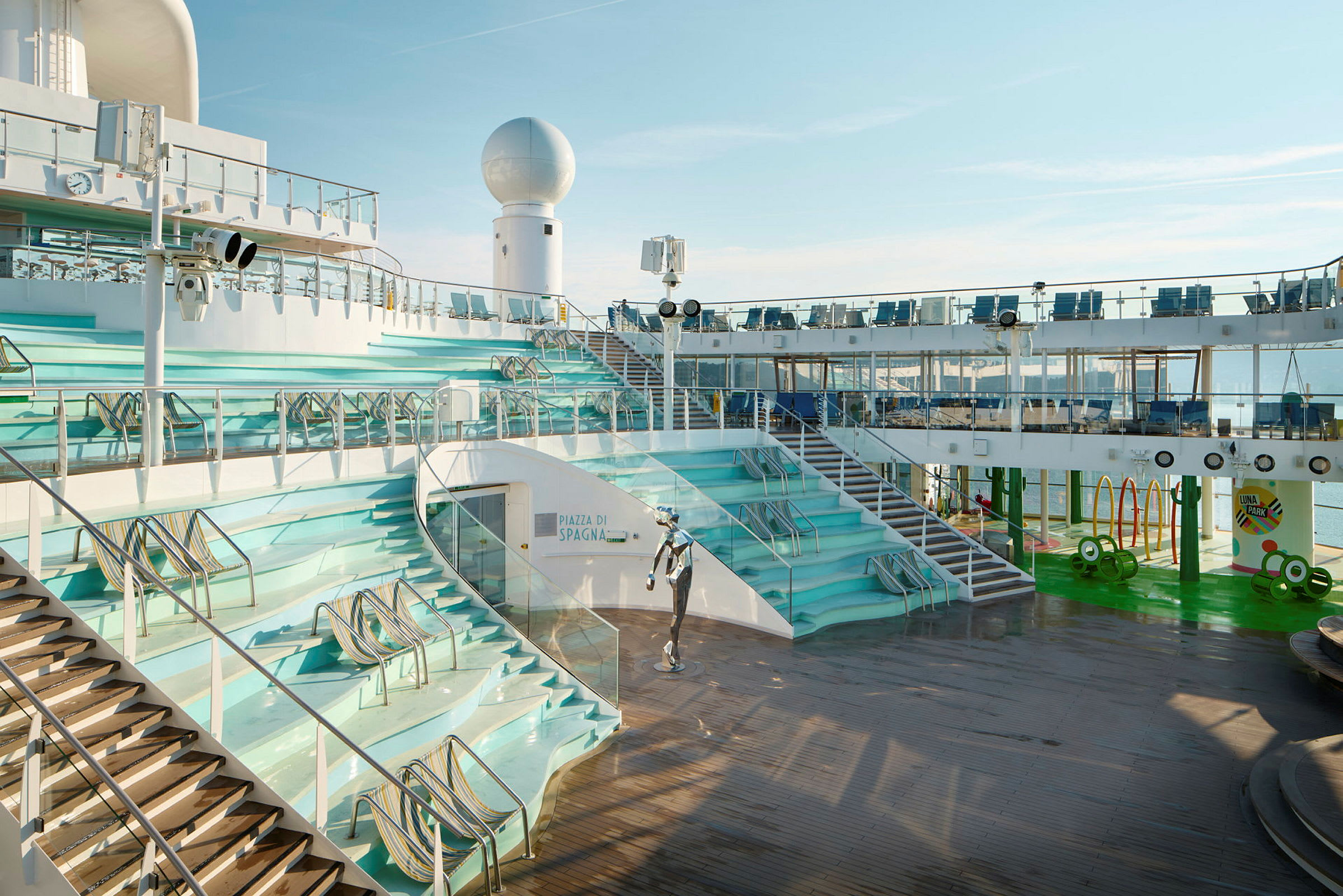 Et åpent dekkområde på et cruiseskip med trapper og sitteplasser. (AI-generert tekst)