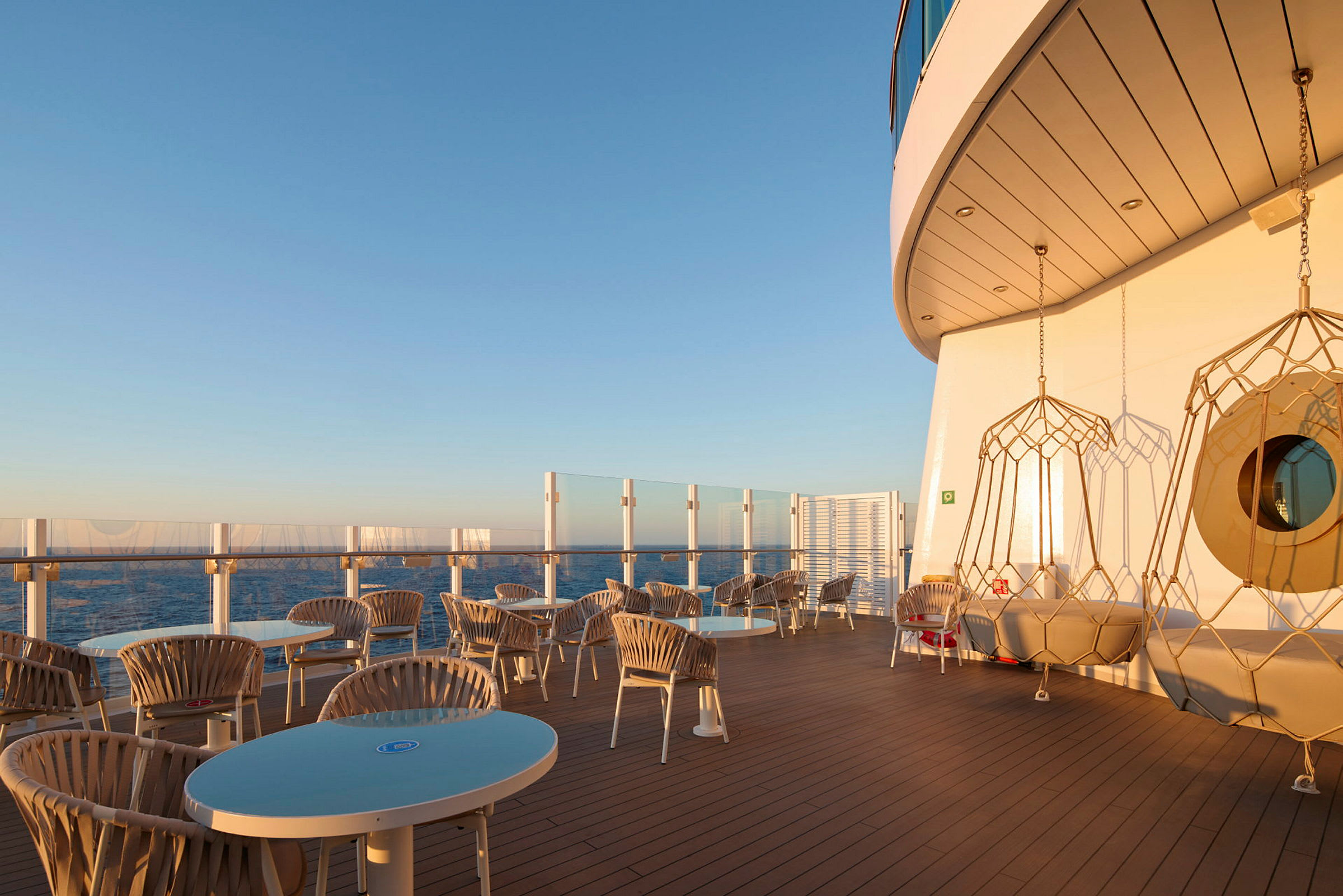 Solbelyst terrasse med sitteplasser og havutsikt. (AI-generert tekst)