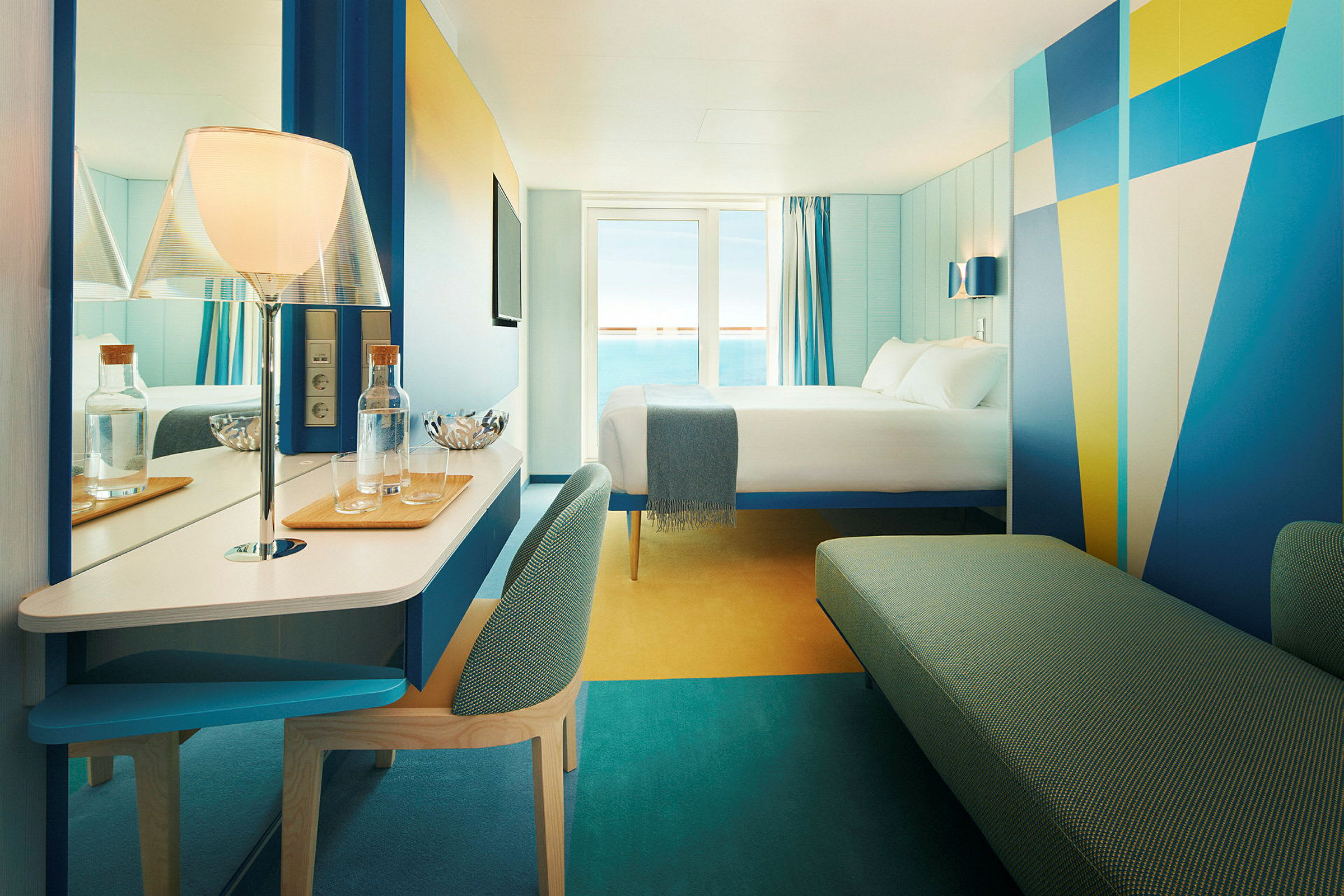 Hotellrom med moderne design og havutsikt. En seng er plassert mot et vindu med blå gardiner. (AI-generert tekst)