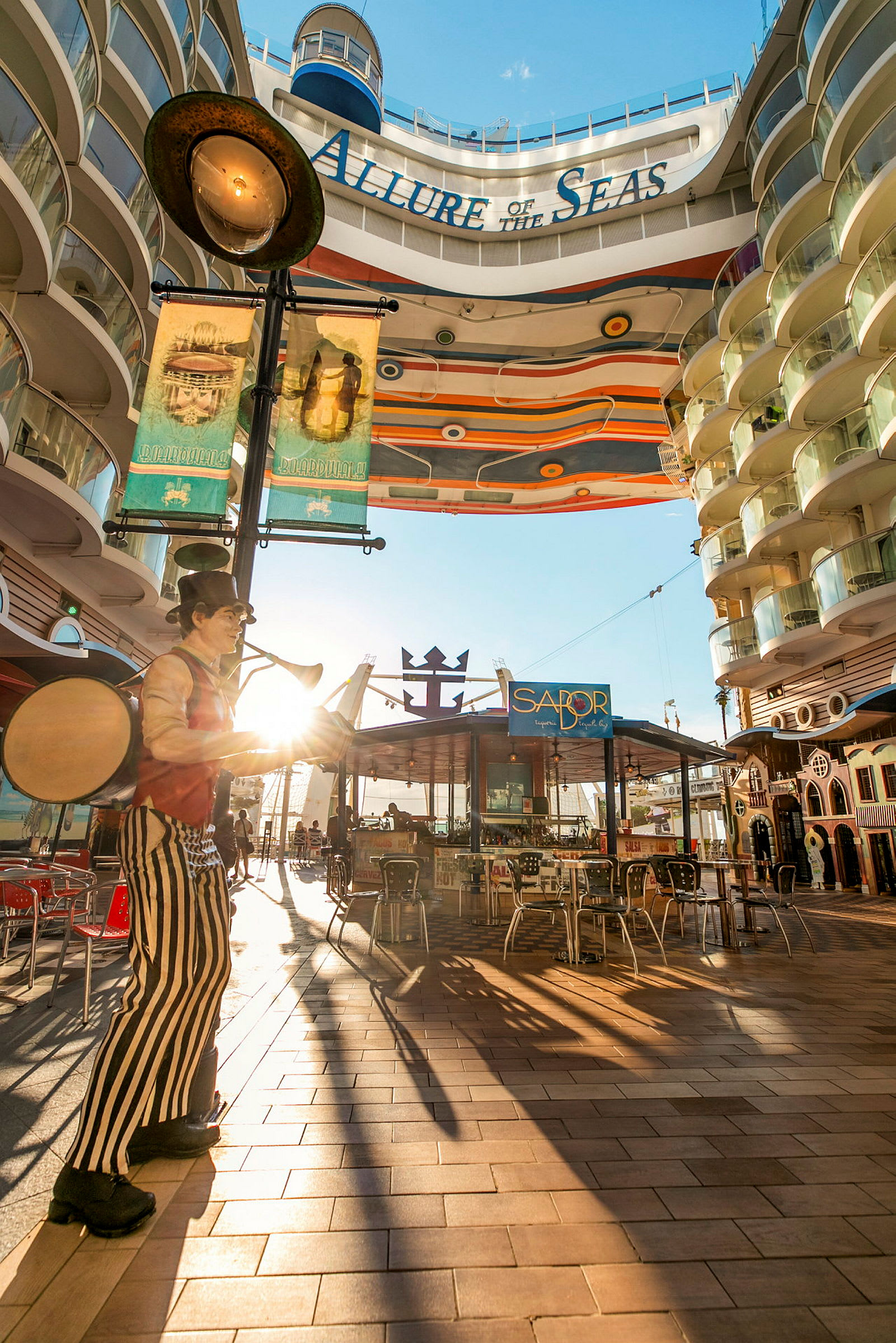 Bilde av et solrikt område ombord på cruiseskipet Allure of the Seas, med en dekorativ gang og restauranter. (AI-generert tekst)
