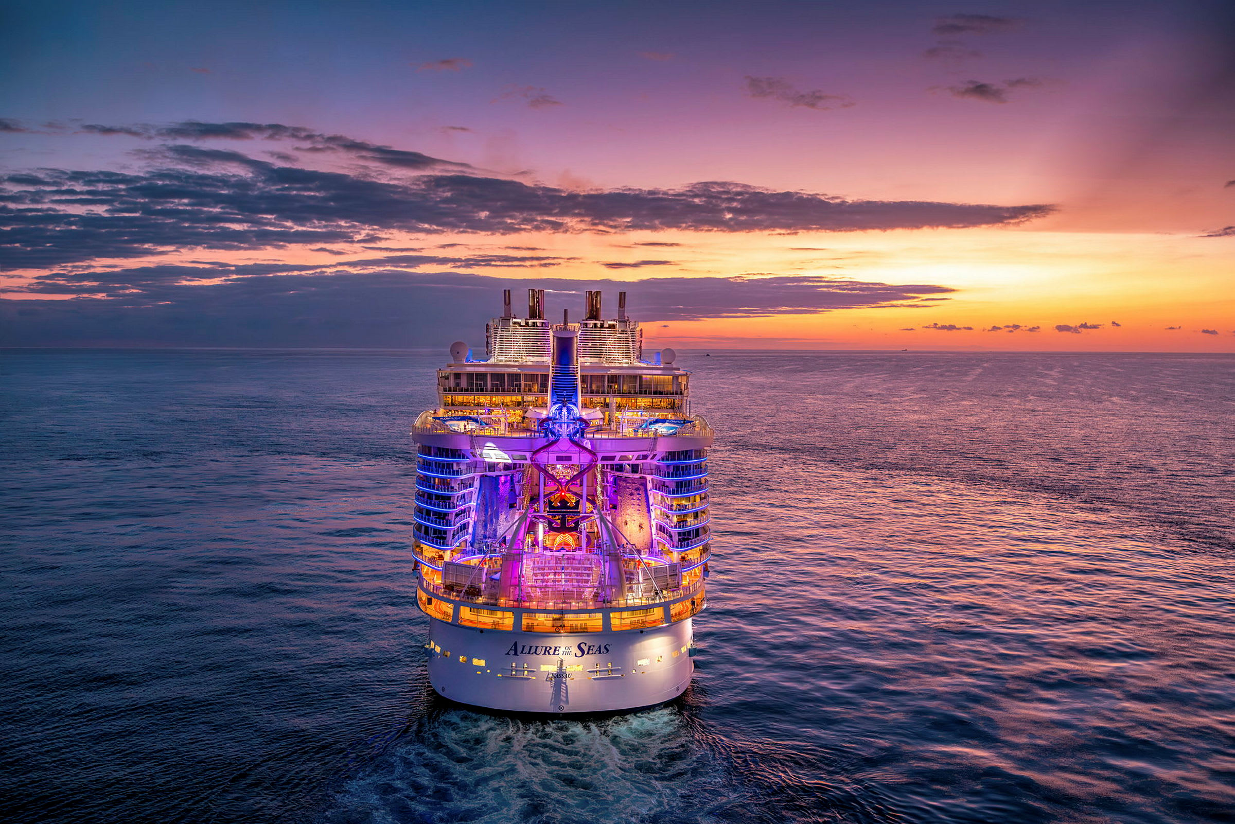 Et opplyst cruiseskip på sjøen ved solnedgang. (AI-generert tekst)