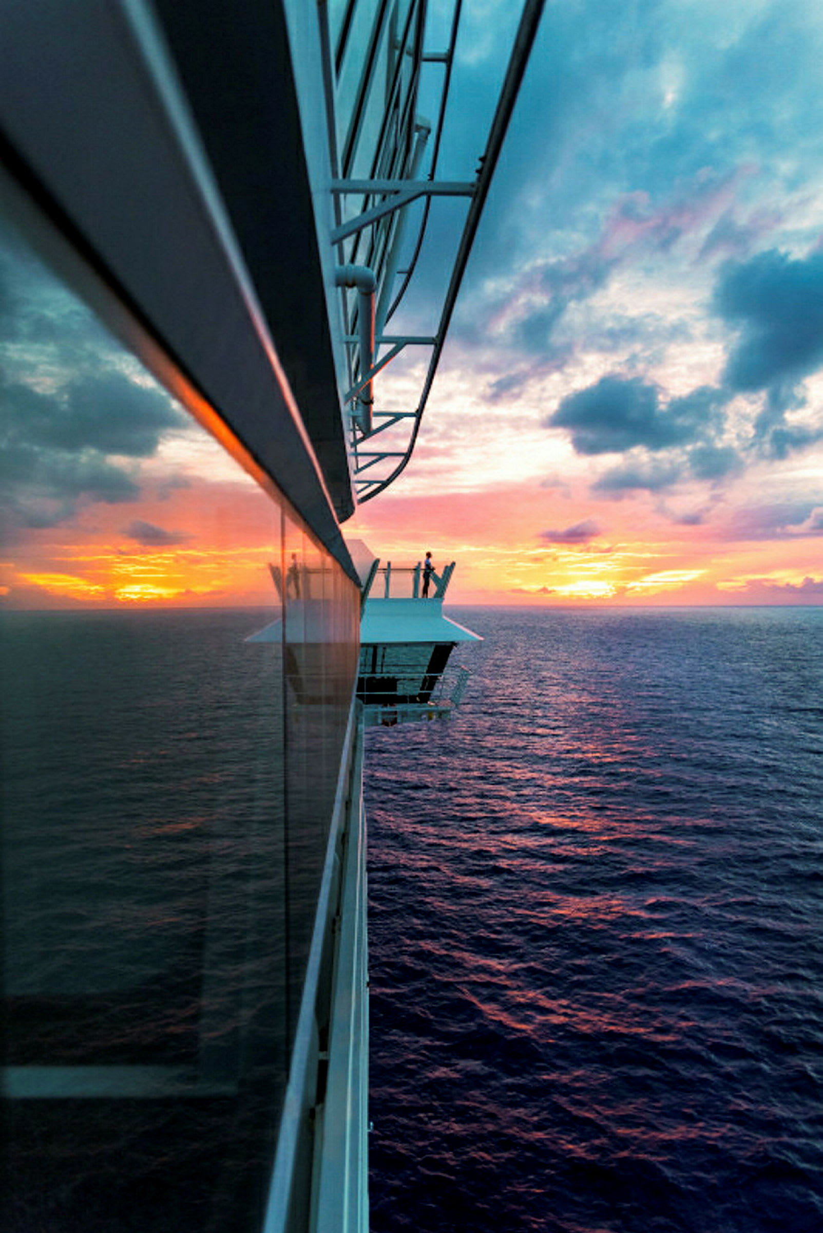 Utsikt fra en cruisebalkong mot solnedgangen over havet. (AI-generert tekst)