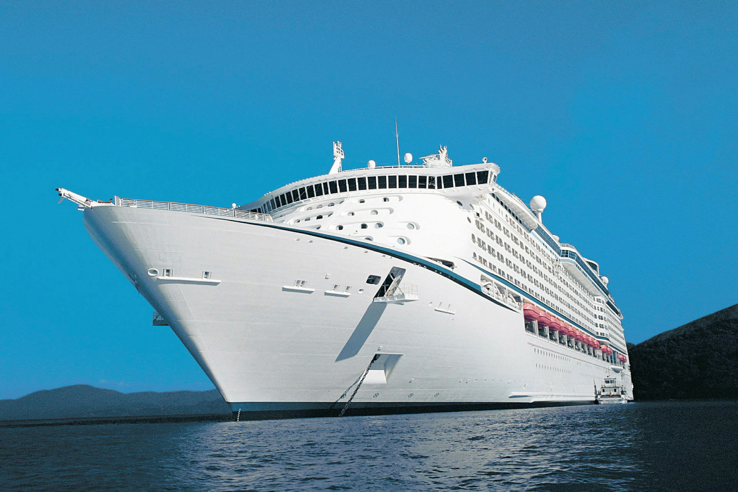 Et stort cruiseskip på havet under en klar blå himmel. (AI-generert tekst)