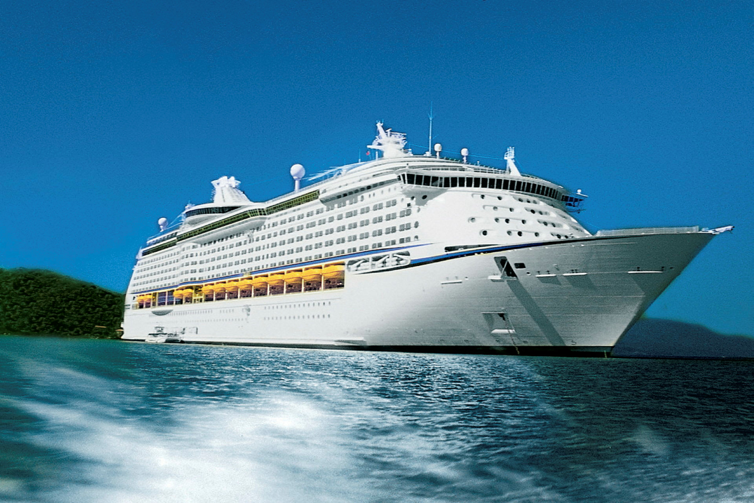 Et stort cruiseskip vises på vannet, omgitt av natur. (AI-generert tekst)