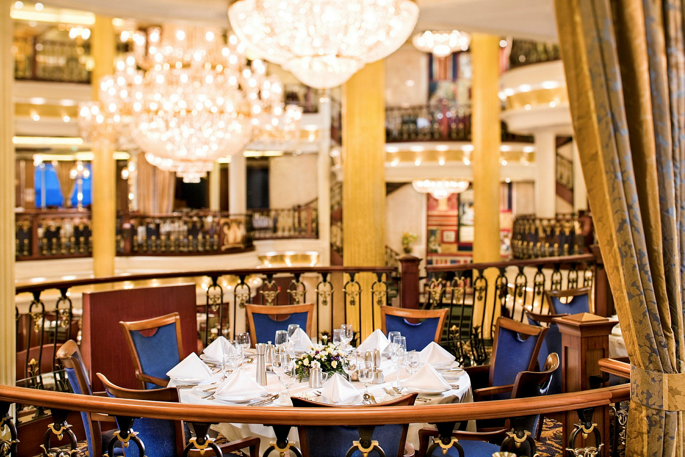 Bilde av et elegant dekket bord med blå stoler i en storslått restaurantinnstilling. (AI-generert tekst)