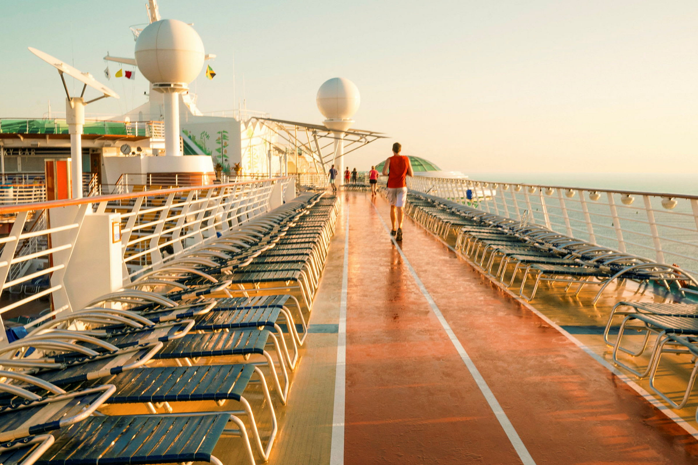 Utsikt over dekket på et cruiseskip med solsenger og personer som går. (AI-generert tekst)