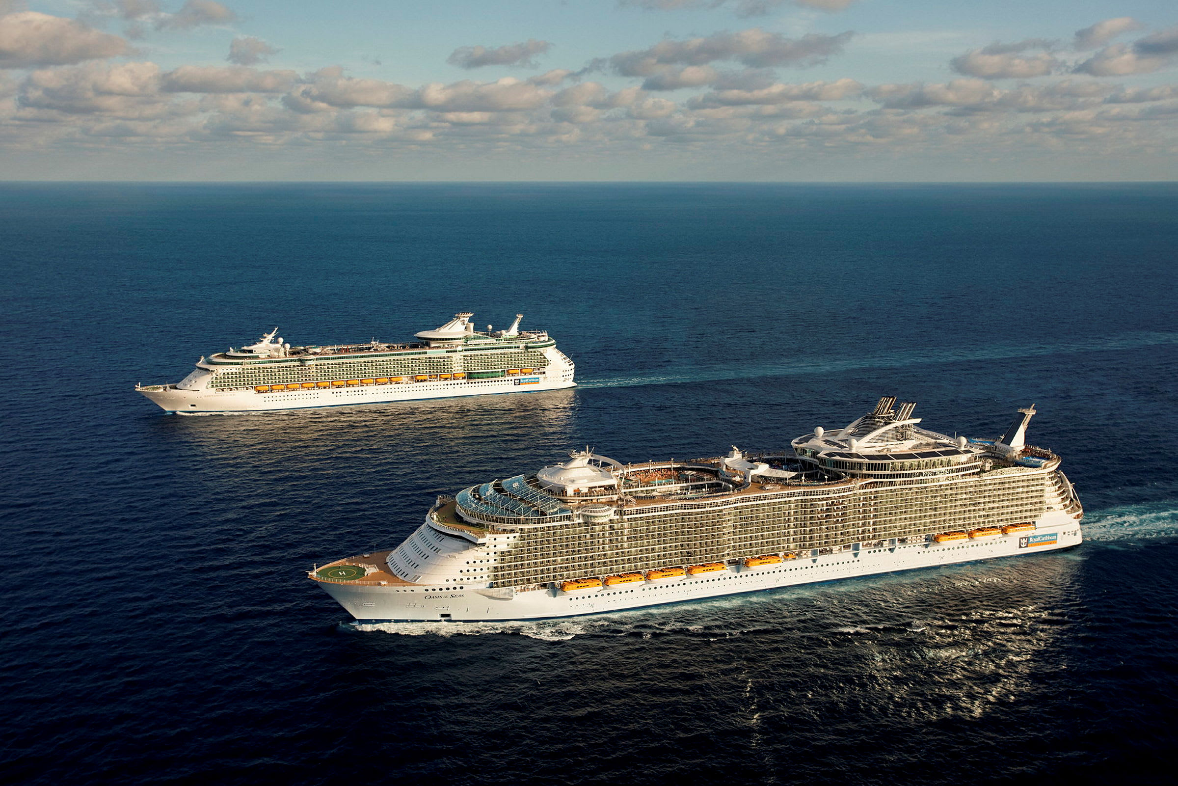 To cruiseskip på havet med blå himmel og skyer. (AI-generert tekst)