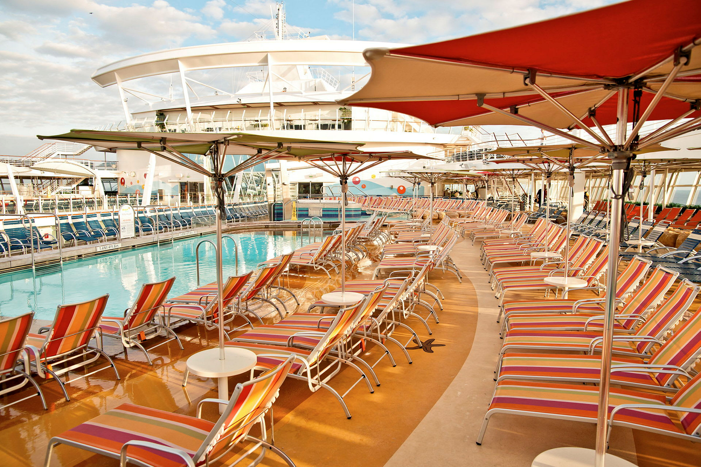 Bassengområde på et cruiseskip med solsenger og parasoller. (AI-generert tekst)