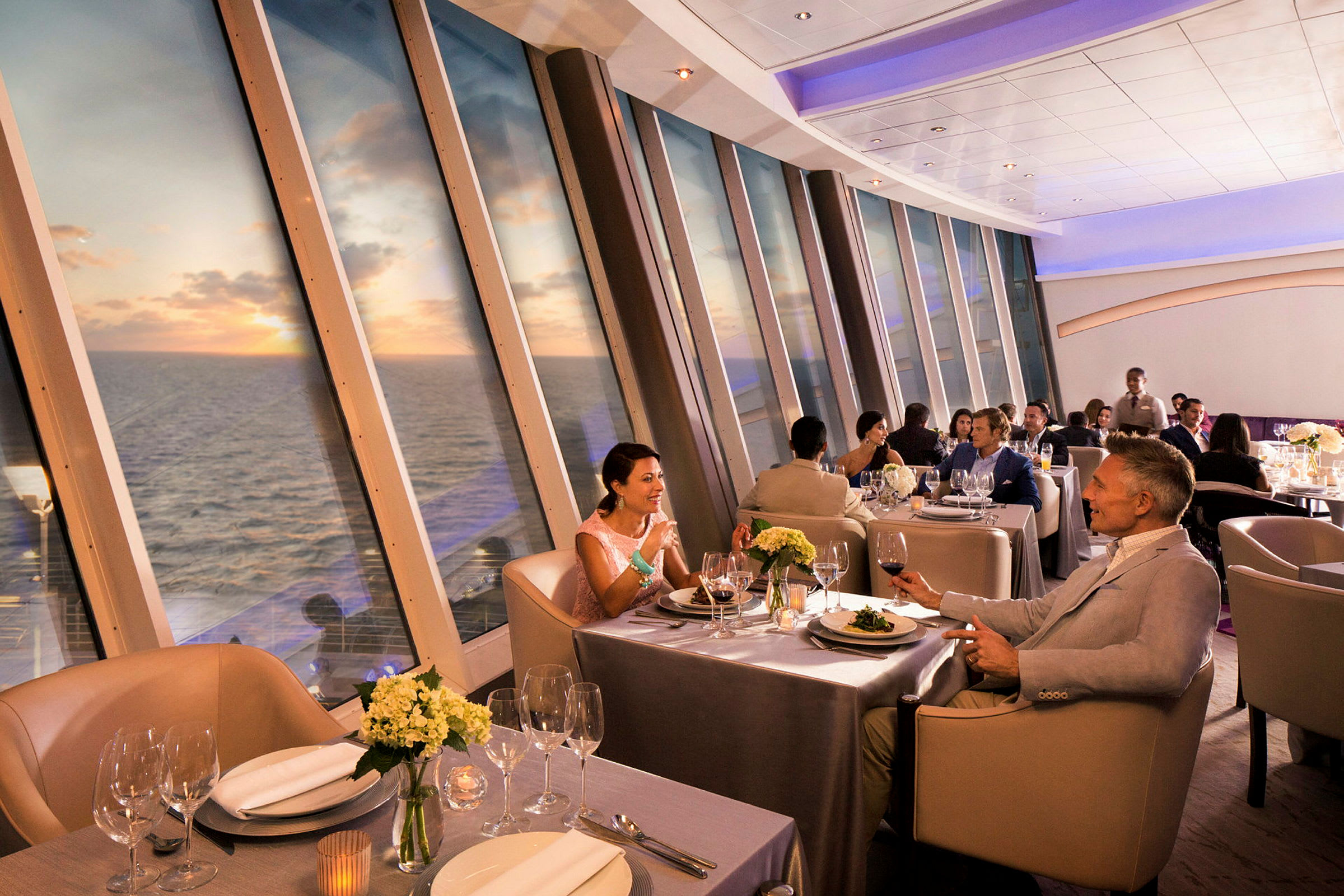 Elegant restaurant med panoramautsikt over havet og solnedgang. (AI-generert tekst)