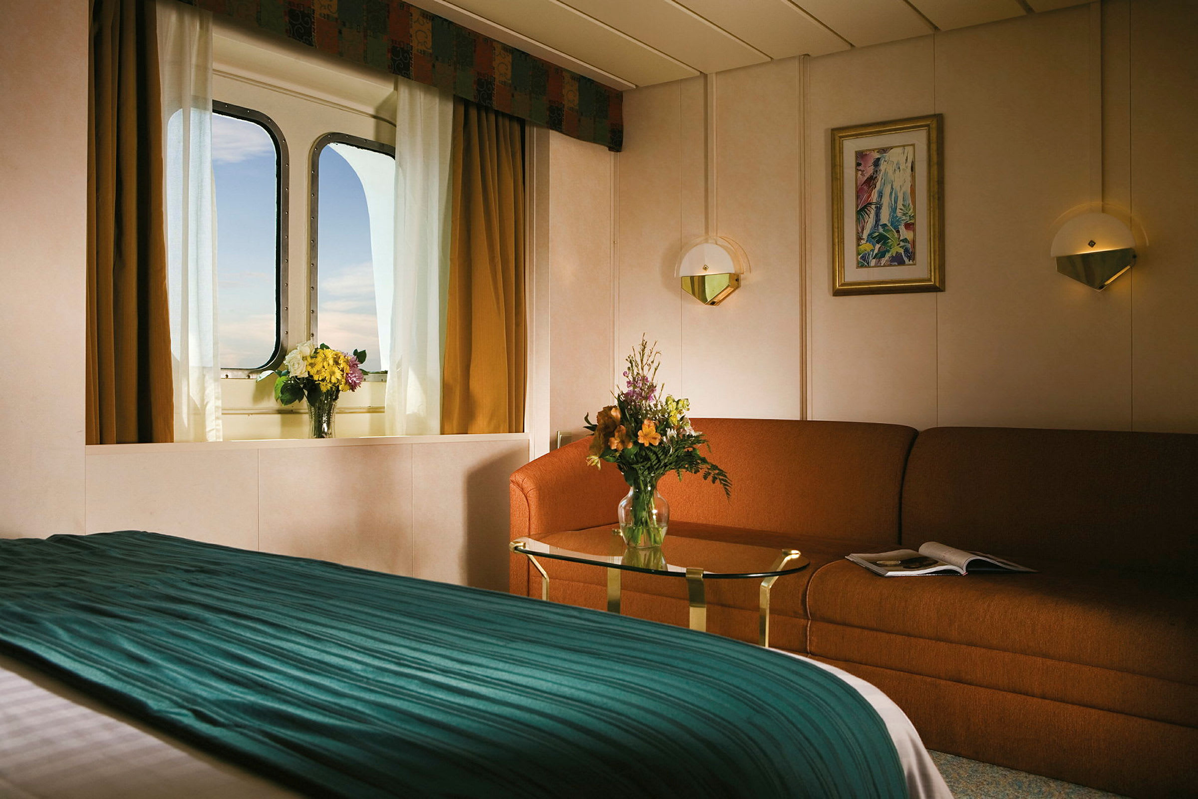 Bilde av et hyggelig hotellrom med sofabord og seng, samt et vindu med utsikt og blomster. (AI-generert tekst)
