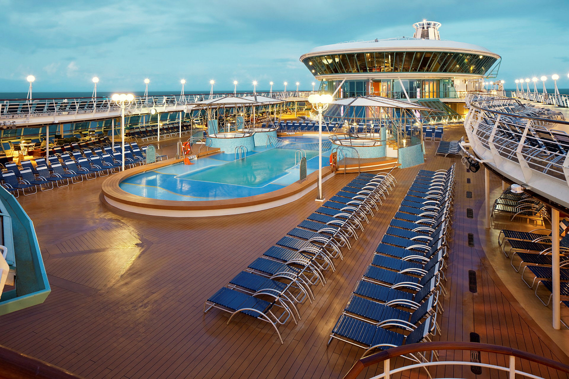 Bassengområde på et cruiseskip med solsenger. (AI-generert tekst)