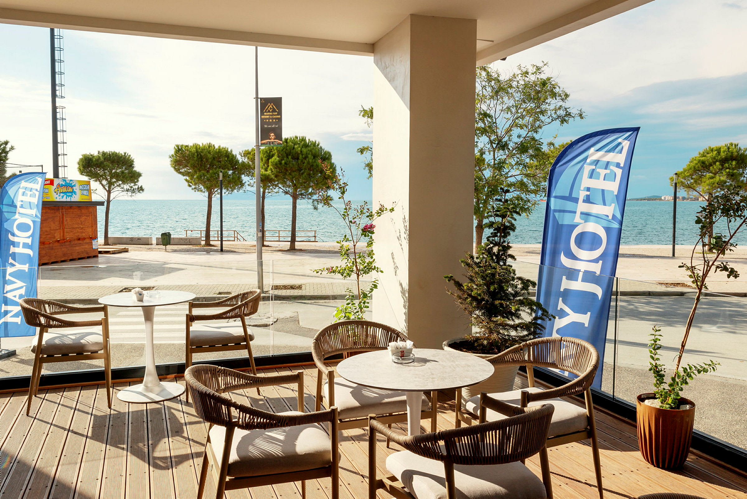 Hotellterrasse med havutsikt og komfortable sitteplasser. (AI-generert tekst)