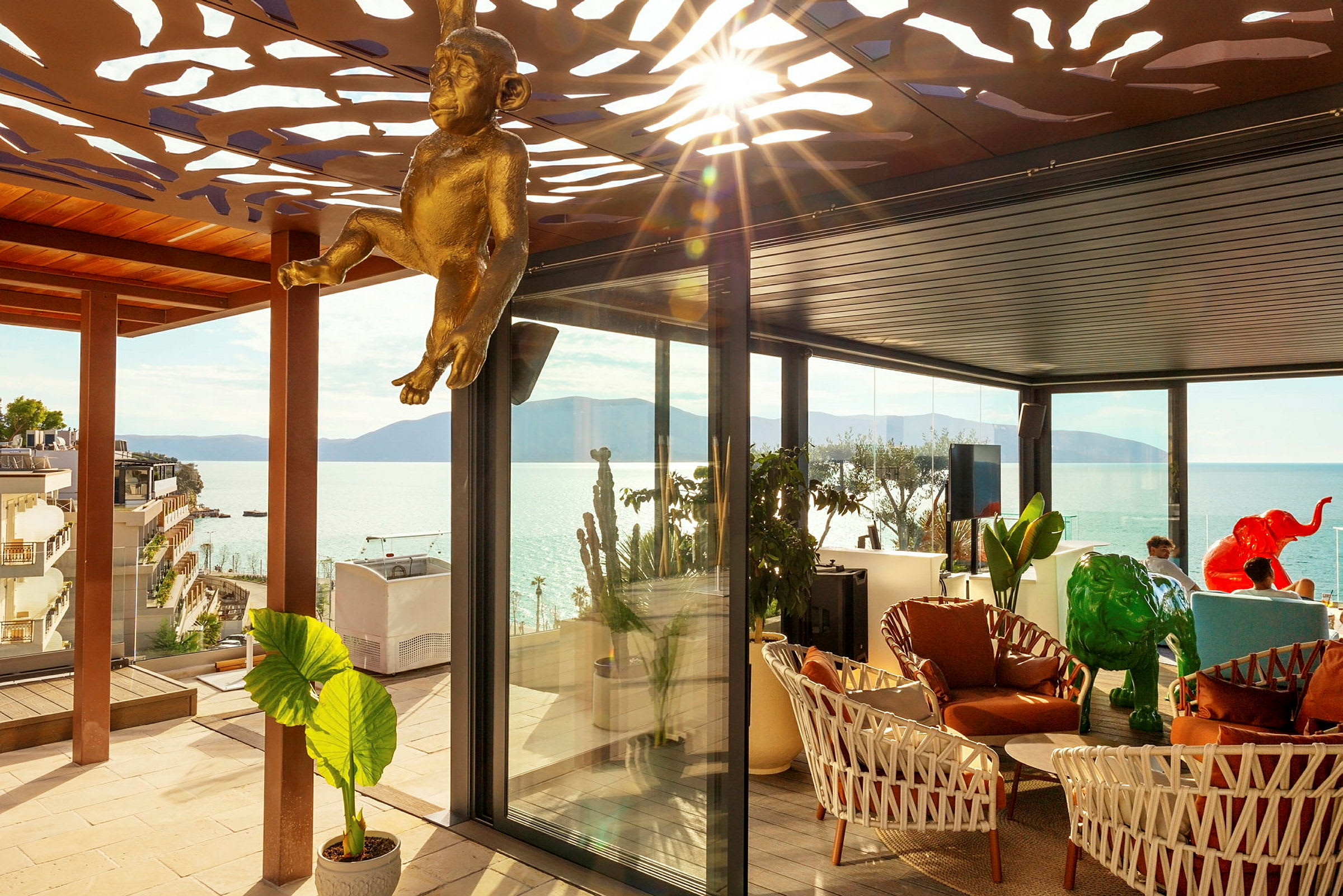 Utsikt over havet fra en elegant terrasse med dekorasjoner og møbler. (AI-generert tekst)