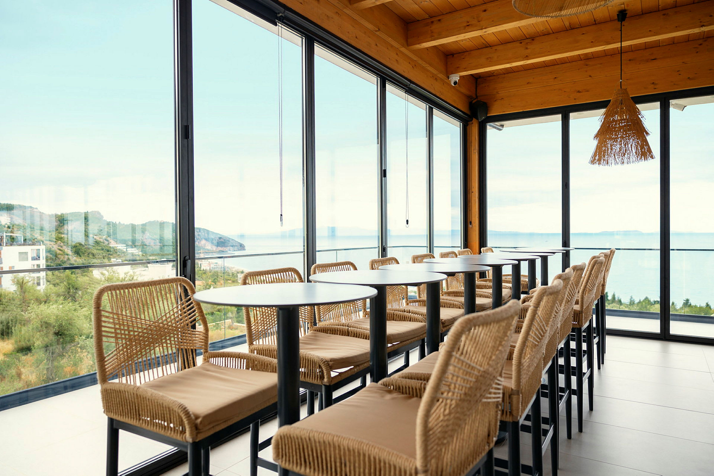 Restaurant med store glassvinduer og utsikt over havet. (AI-generert tekst)