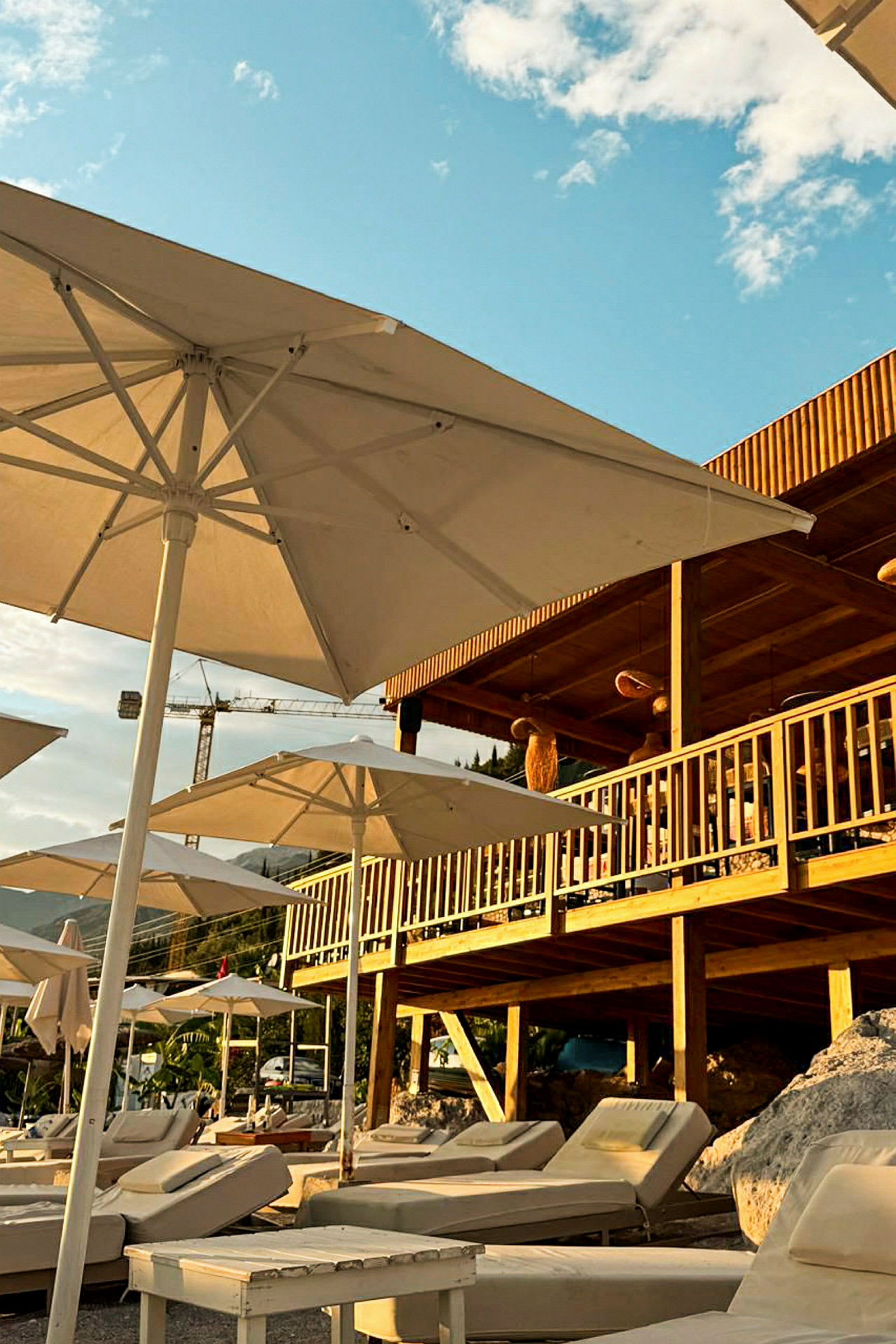 Solsenger og parasoller på en terrasse ved en strand. (AI-generert tekst)