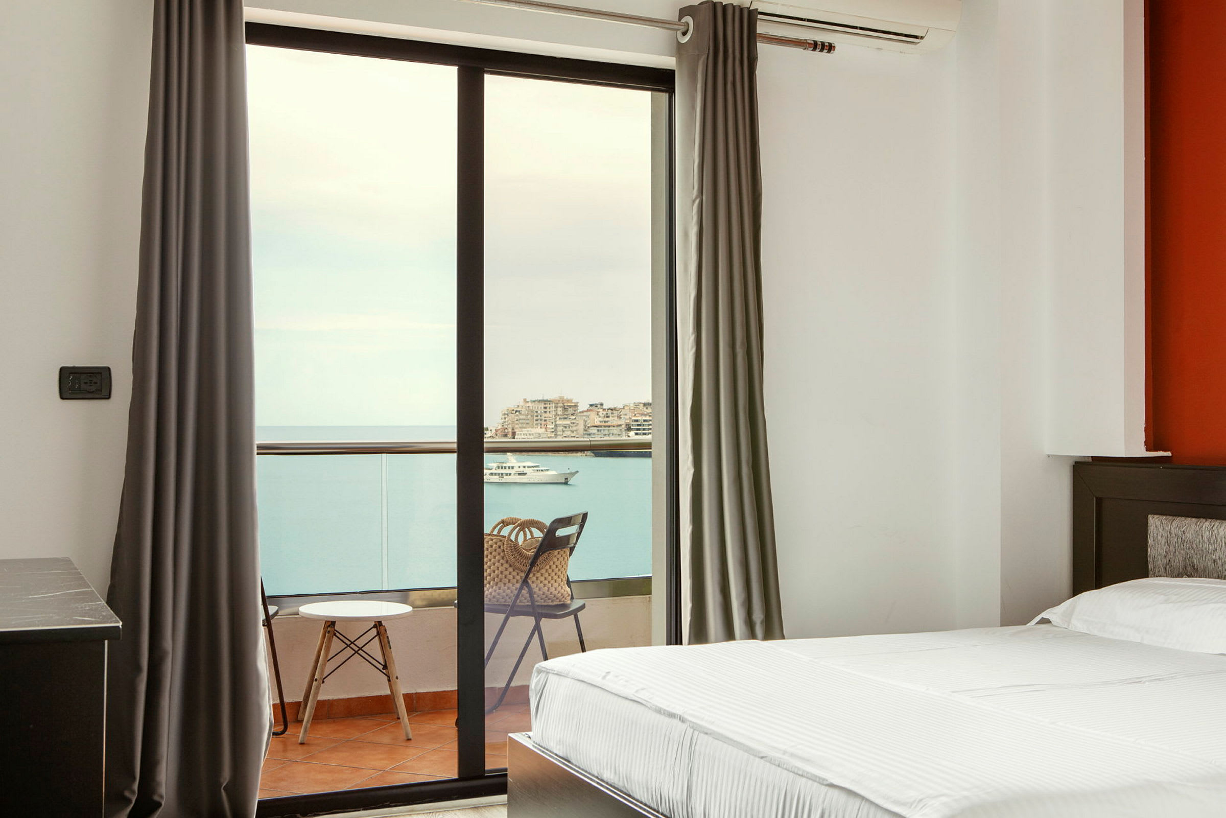 Hotellrom med balkong og utsikt over havet. (AI-generert tekst)