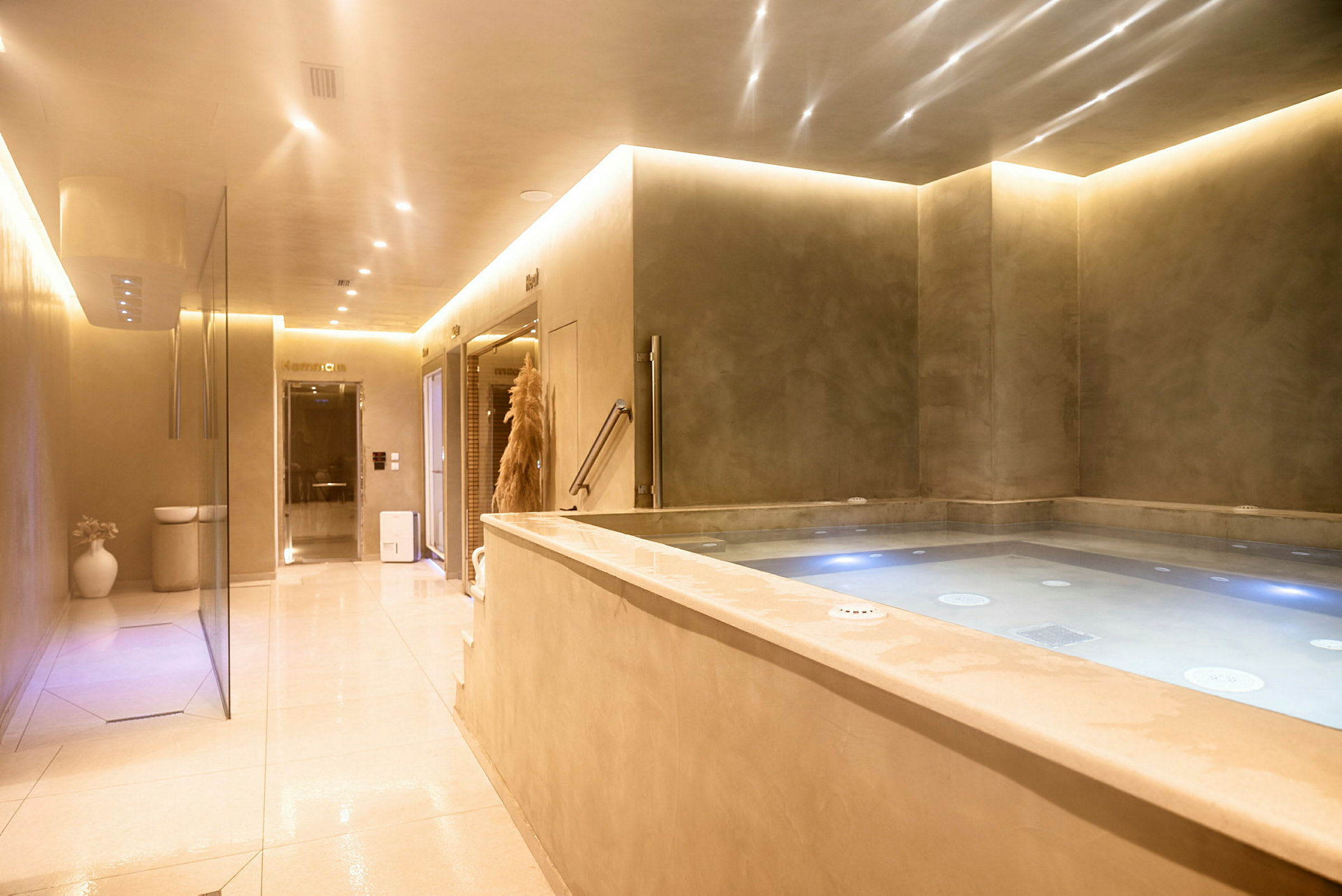 En avslappet innendørsmiljø med en jacuzzi og belysning. (AI-generert tekst)