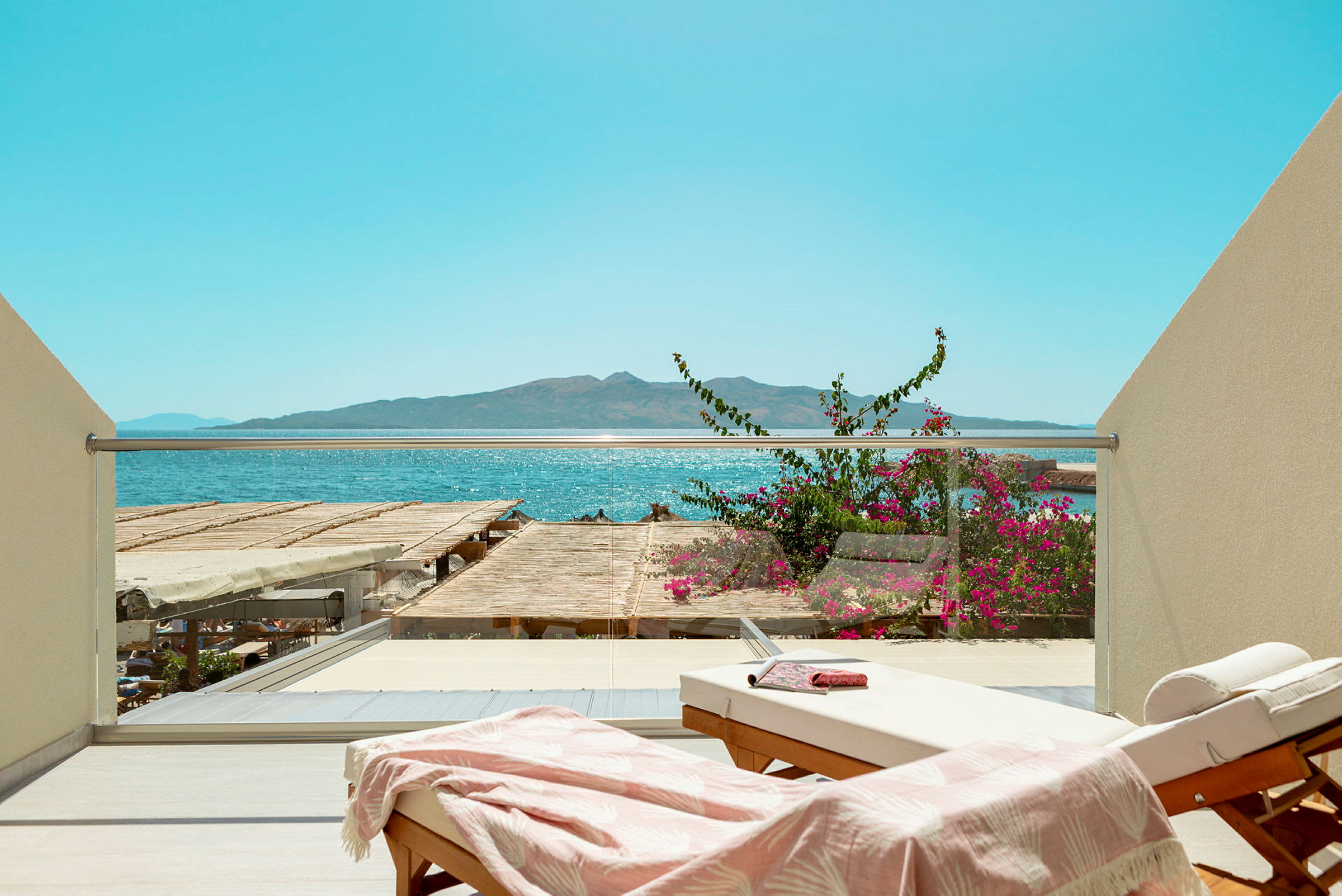 Solstol på balkon med utsikt over havet og blomster. (AI-generert tekst)