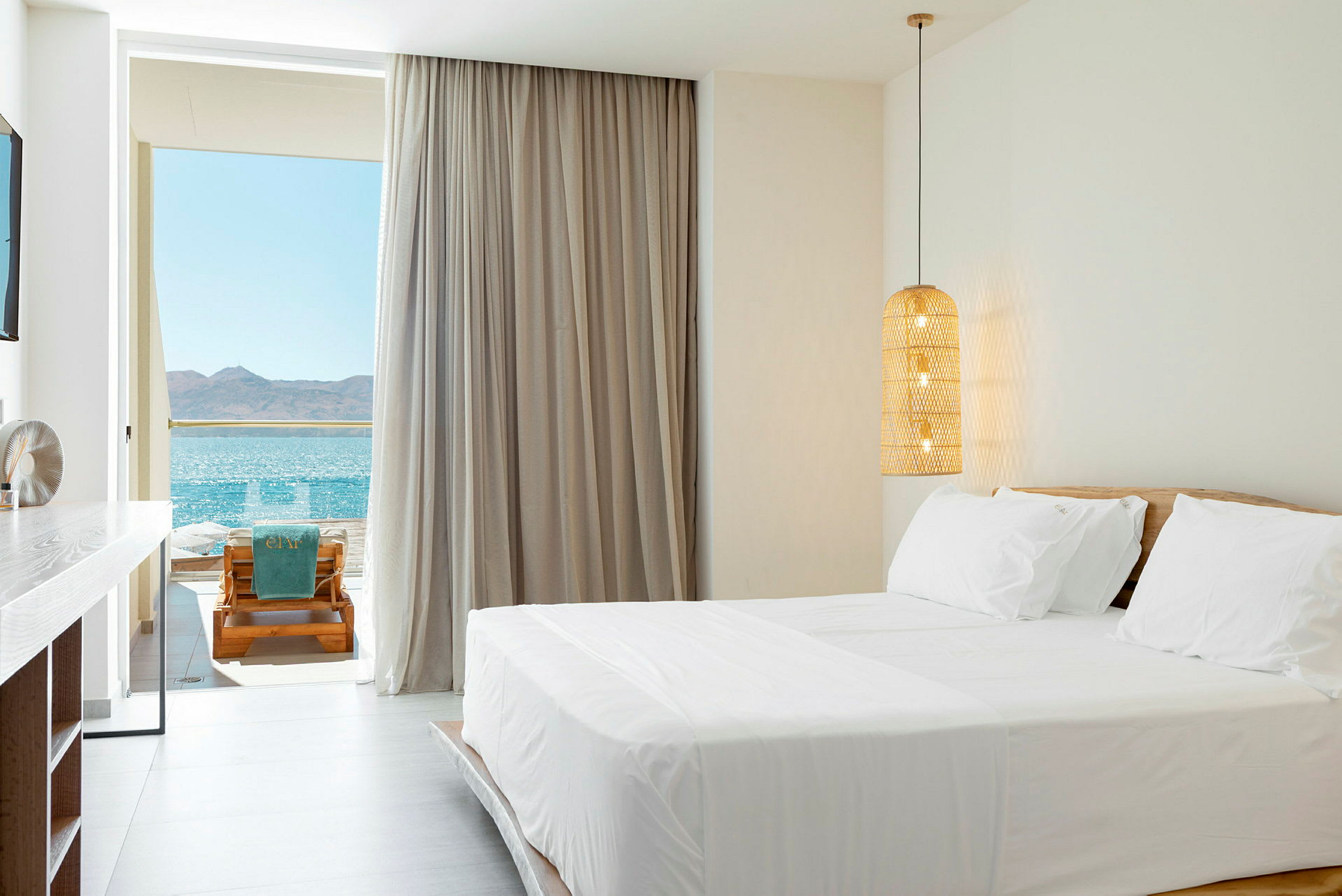 Lyst og moderne hotellrom med havutsikt fra balkongen. (AI-generert tekst)