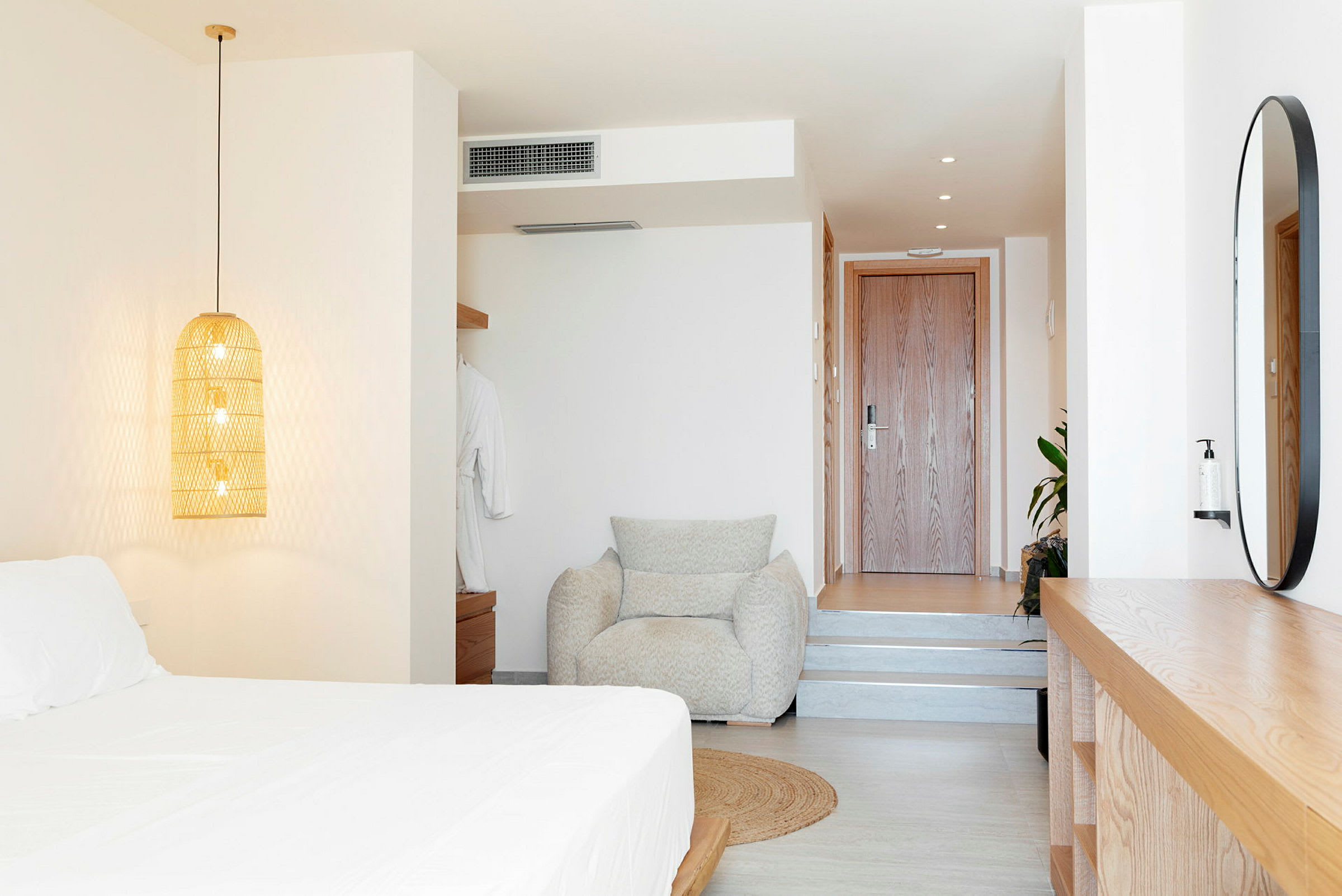 Moderne innredet hotellrom med seng, lenestol og tredetaljer. (AI-generert tekst)