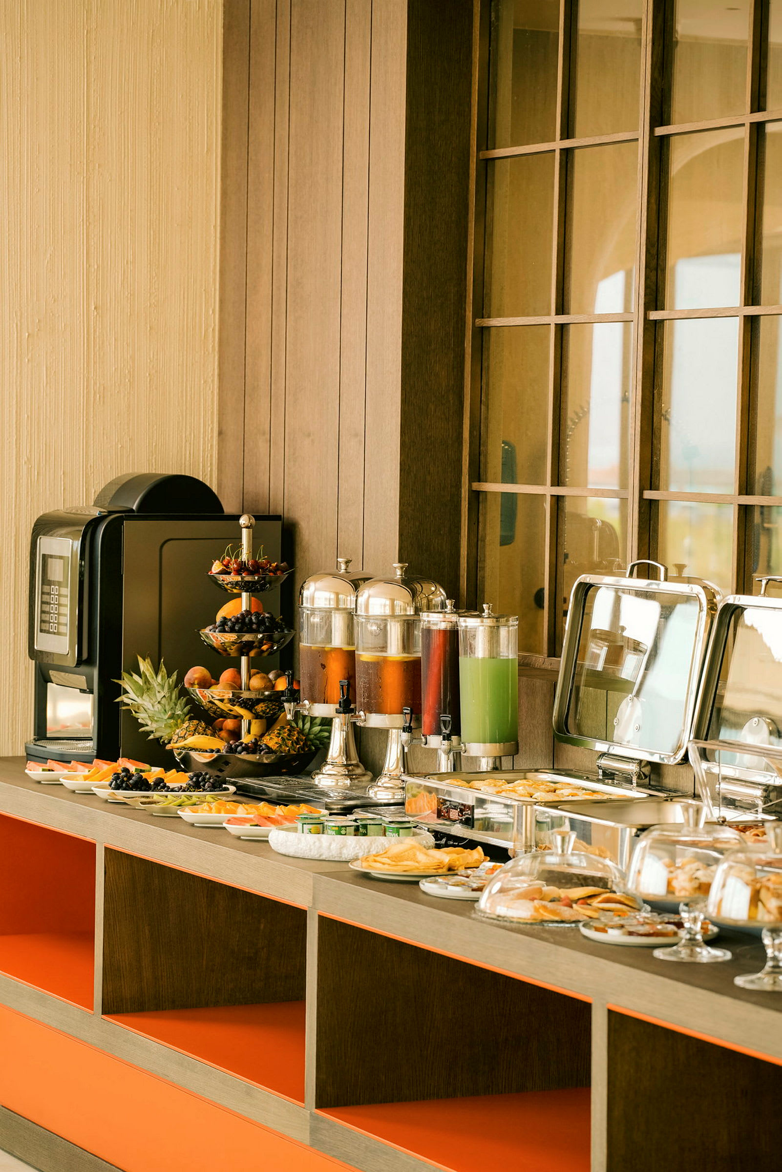 En frokostbuffé med forskjellige retter, frukt, juiceautomater og en kaffemaskin. (AI-generert tekst)