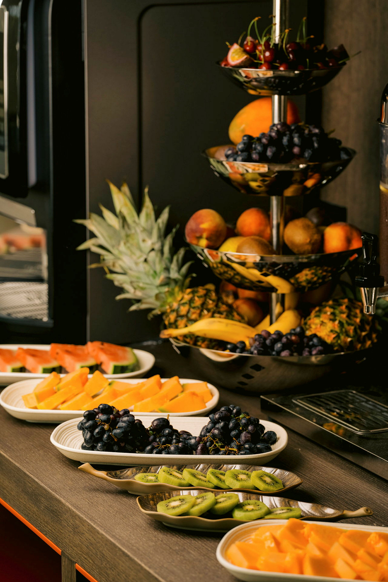En bufféoppsett med ulike ferske frukter som druer, kiwi, vannmelon og ananas. (AI-generert tekst)
