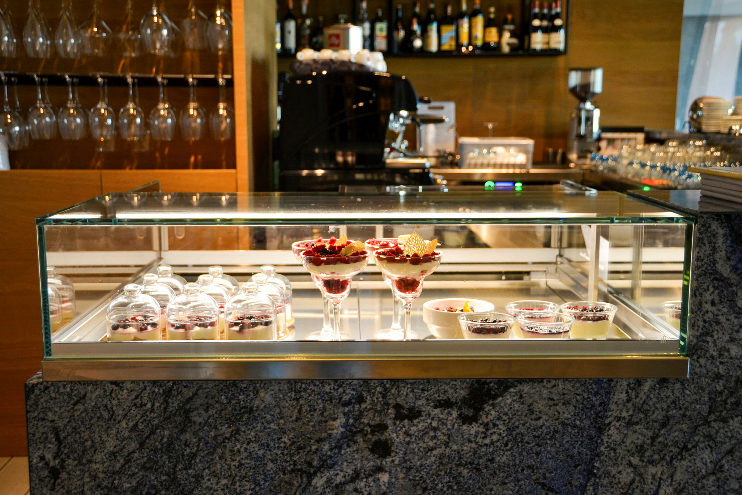 Bilde av en glassmonter med diverse desserter på en restaurant. (AI-generert tekst)