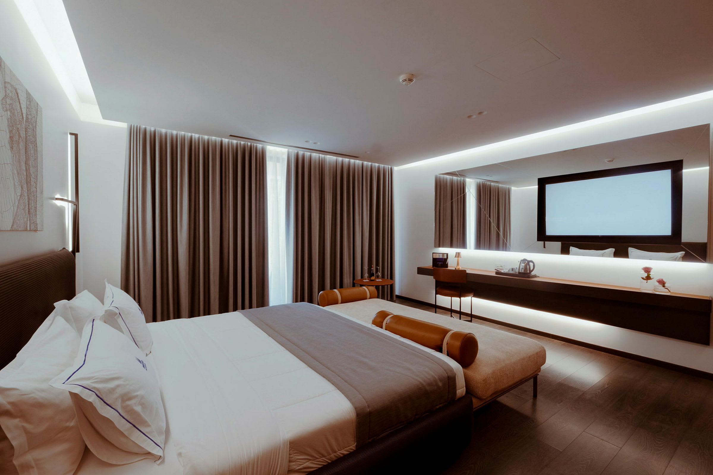 Moderne hotellrom med dobbeltseng, skrivebord og speil. (AI-generert tekst)