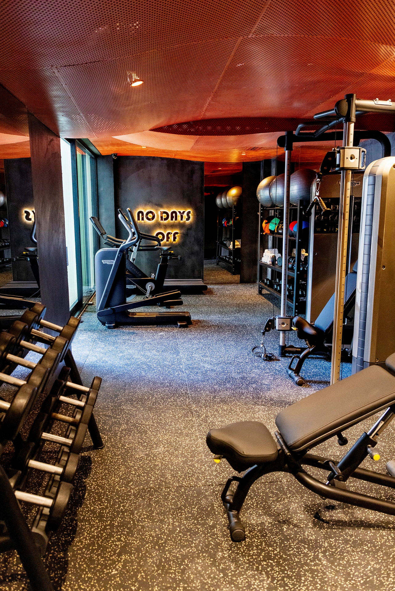 Et moderne treningsstudio med treningsutstyr som manualer, maskiner og ergometersykler. (AI-generert tekst)
