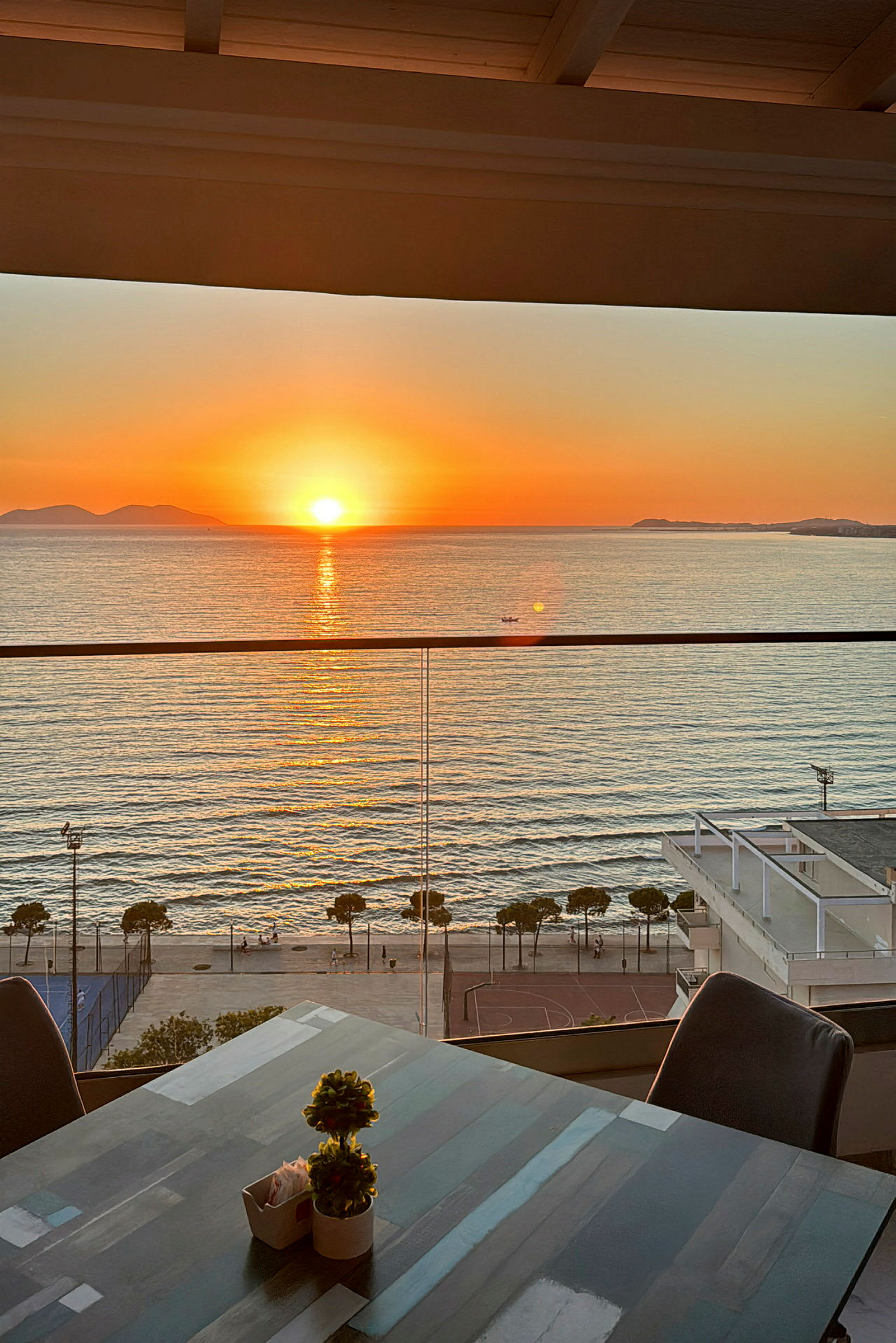 En solnedgang over havet, sett fra en terrasse med utsikt. (AI-generert tekst)