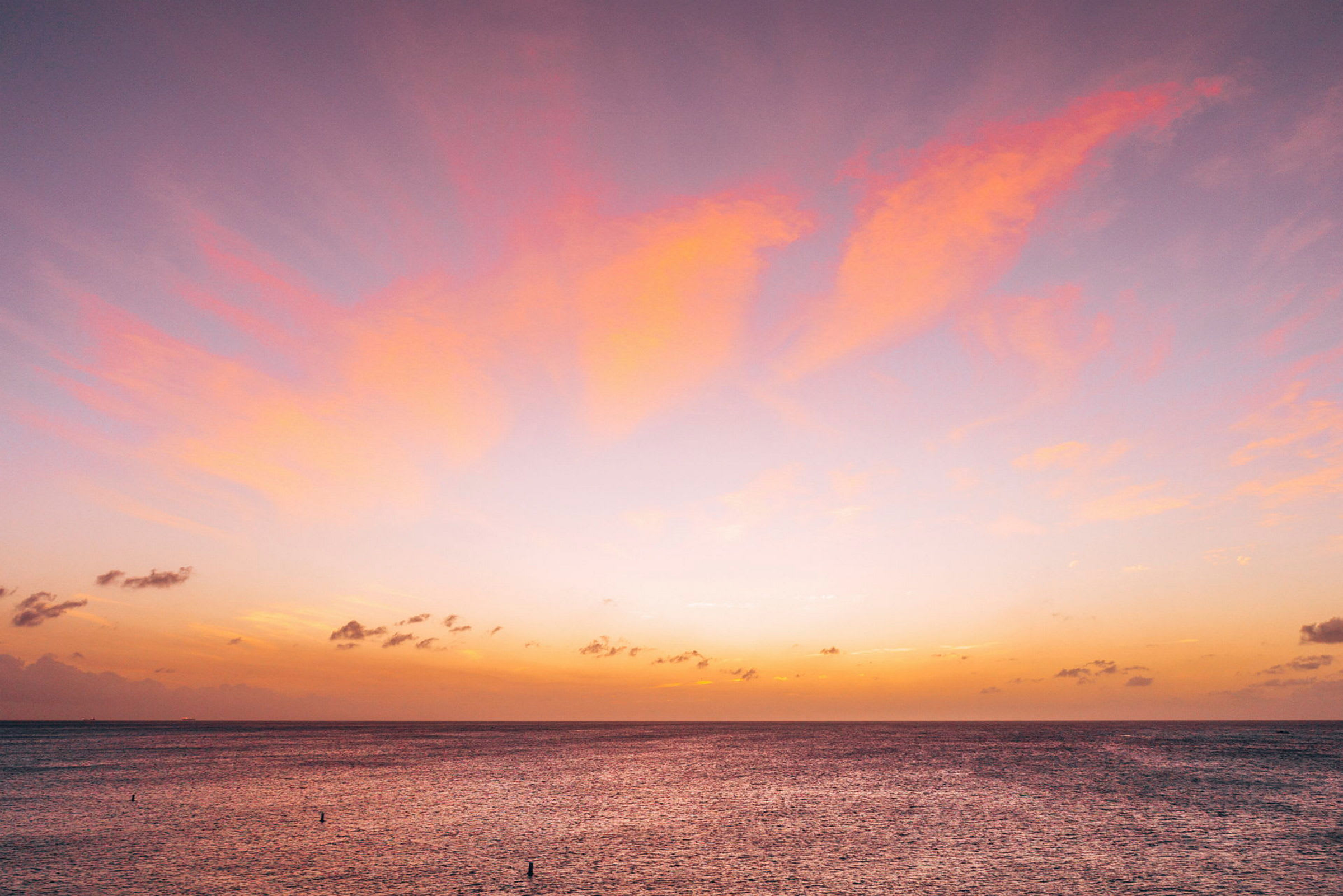 Horisonten viser en solnedgang over et rolig hav med rosa og oransje farger på himmelen. (AI-generert tekst)