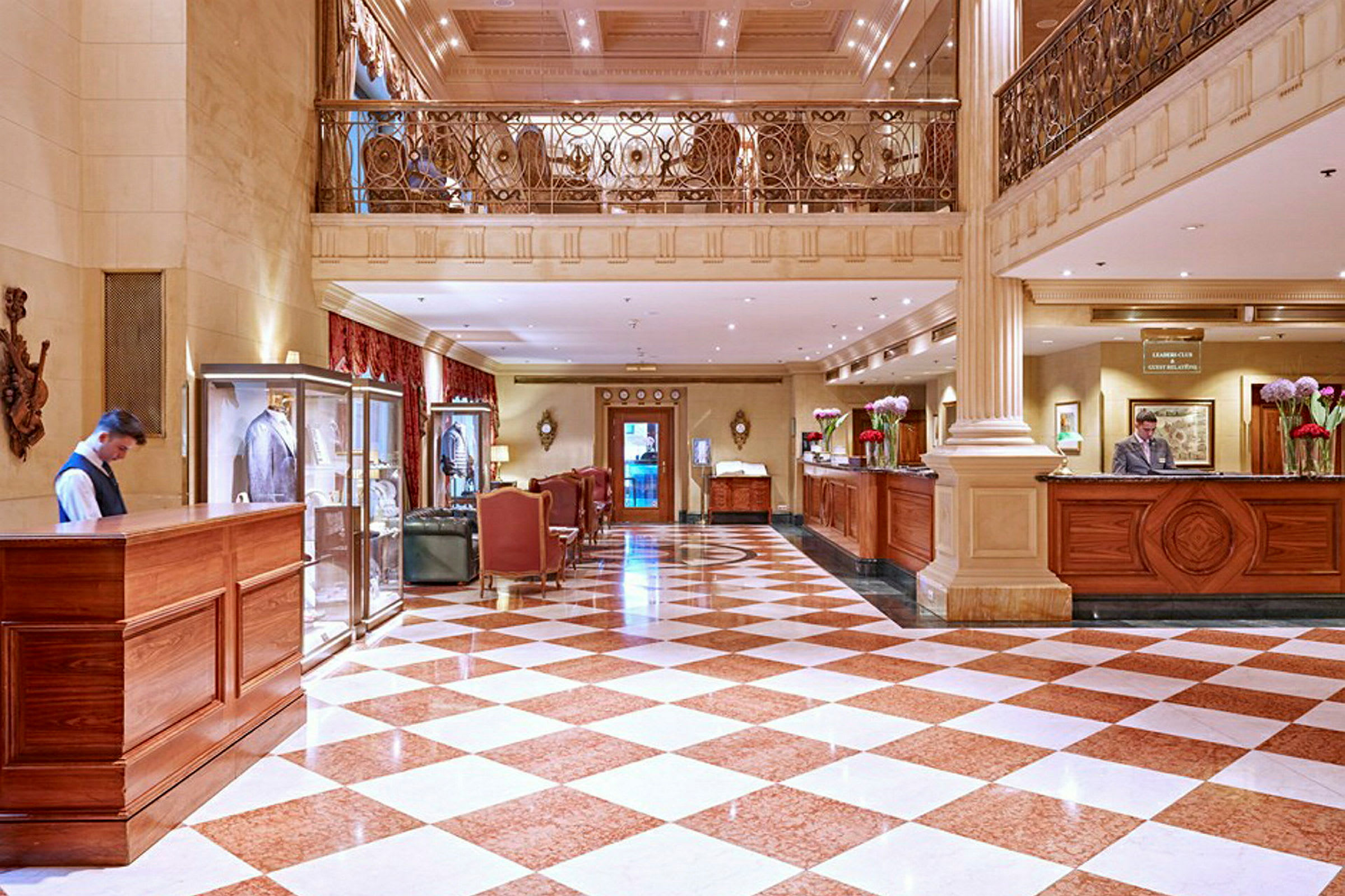 Bildet viser et hotellfoajé med marmorgulv, resepsjon og elegant interiør. (AI-generert tekst)