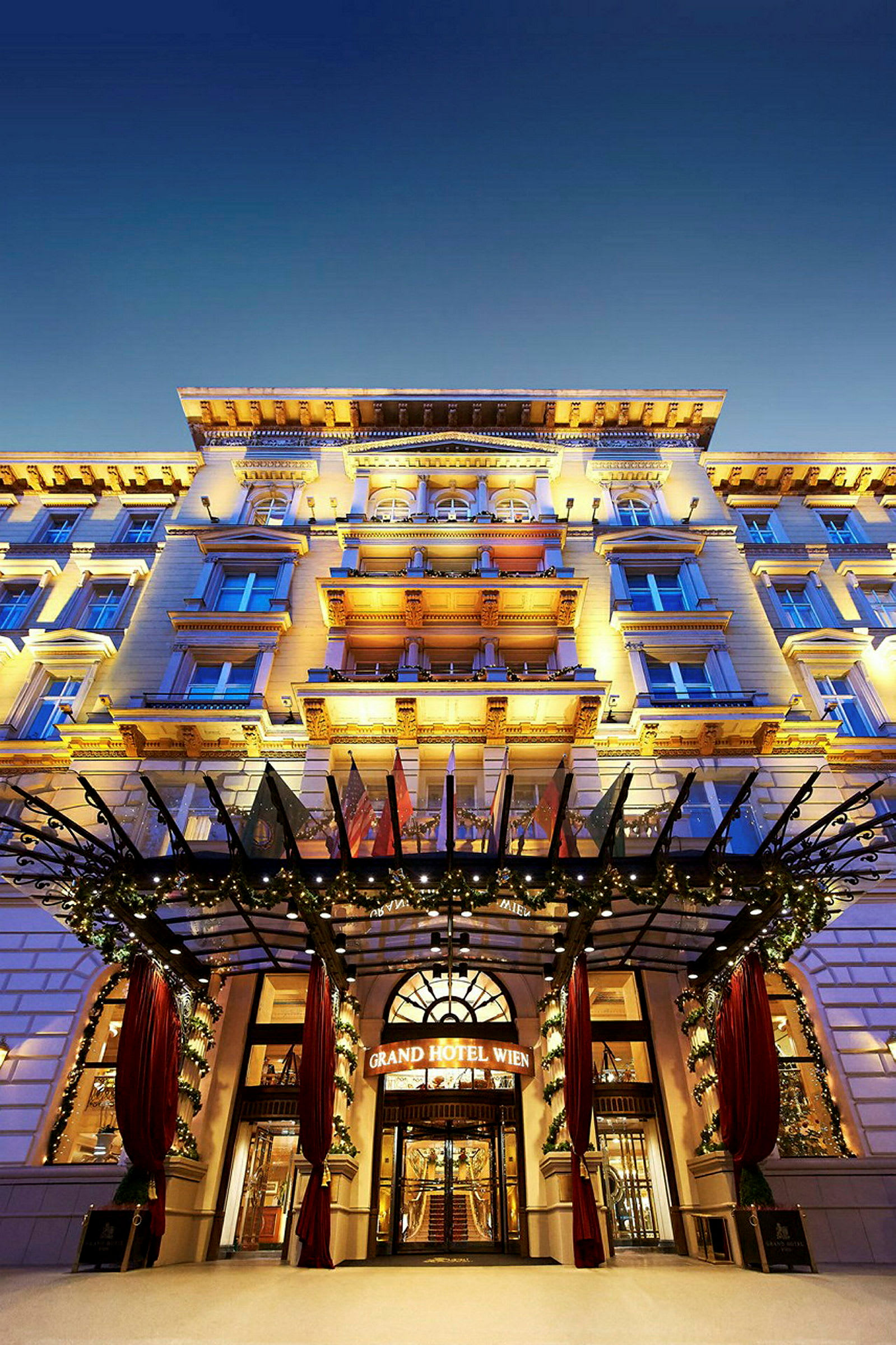 Fasaden til Grand Hotel Wien med opplyste detaljer og dekorasjoner. (AI-generert tekst)
