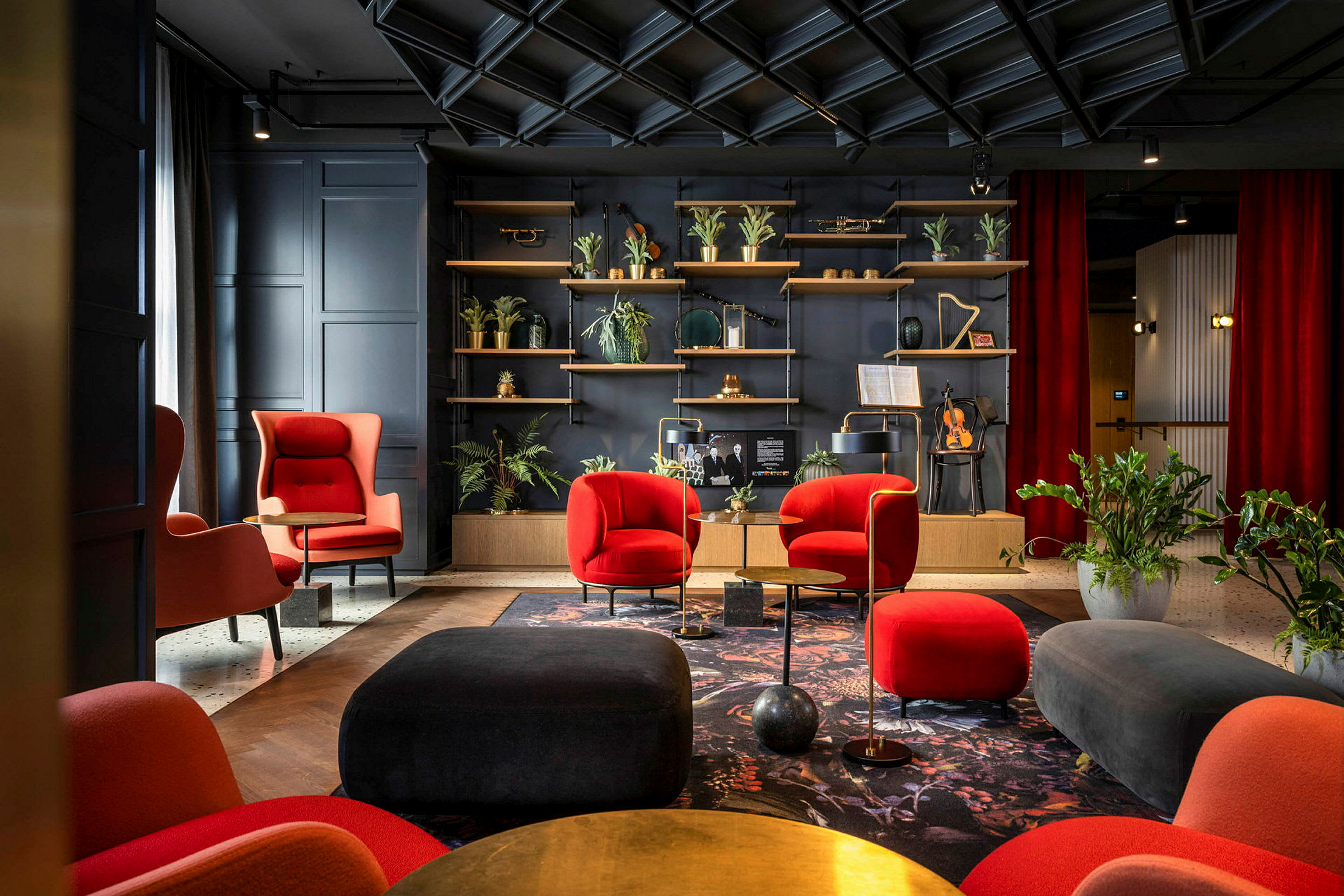 Elegant lounge med røde og svarte møbler, planter og en hylle med dekorative gjenstander. (AI-generert tekst)
