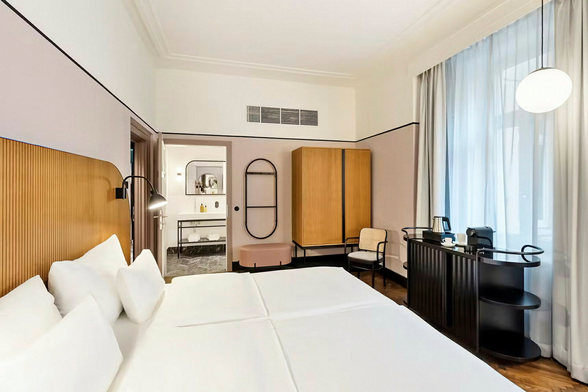 Et hotellrom med en dobbeltseng, garderobe, stol og et skrivebord med kaffetrakter. (AI-generert tekst)