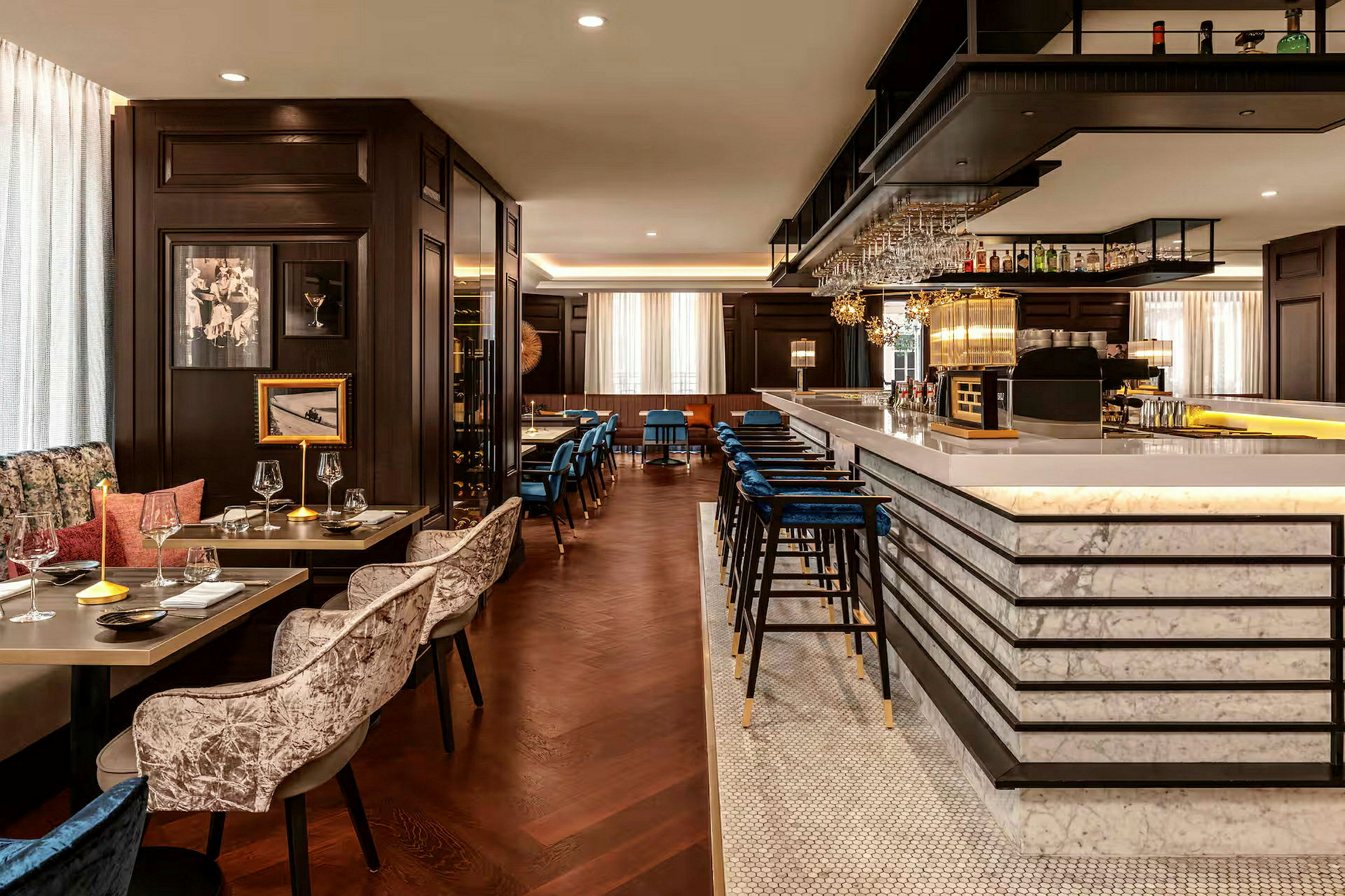 En elegant restaurant og bar med marmordekket bardisk, fløyelsstoler og en koselig atmosfære. (AI-generert tekst)