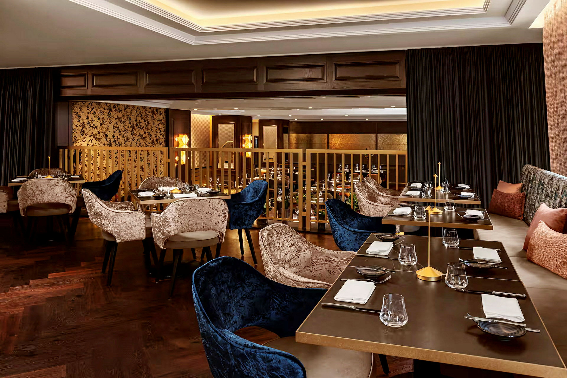 En elegant restaurant med dekte bord og polstrede stoler. Interiøret er innredet med mørke tredetaljer og myke tekstiler. (AI-generert tekst)