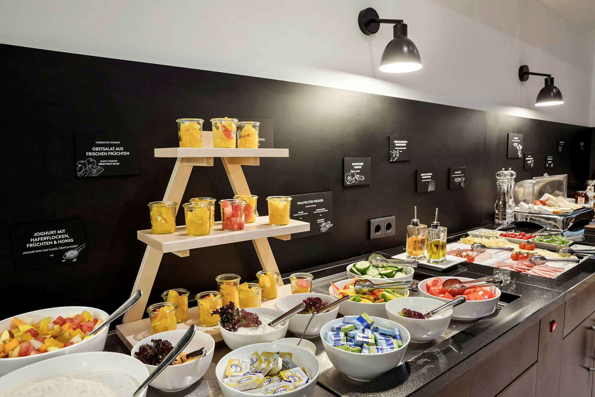 Frokostbuffé med frukt i glasskrukker, skiver av grønnsaker, pålegg og tilbehør. (AI-generert tekst)