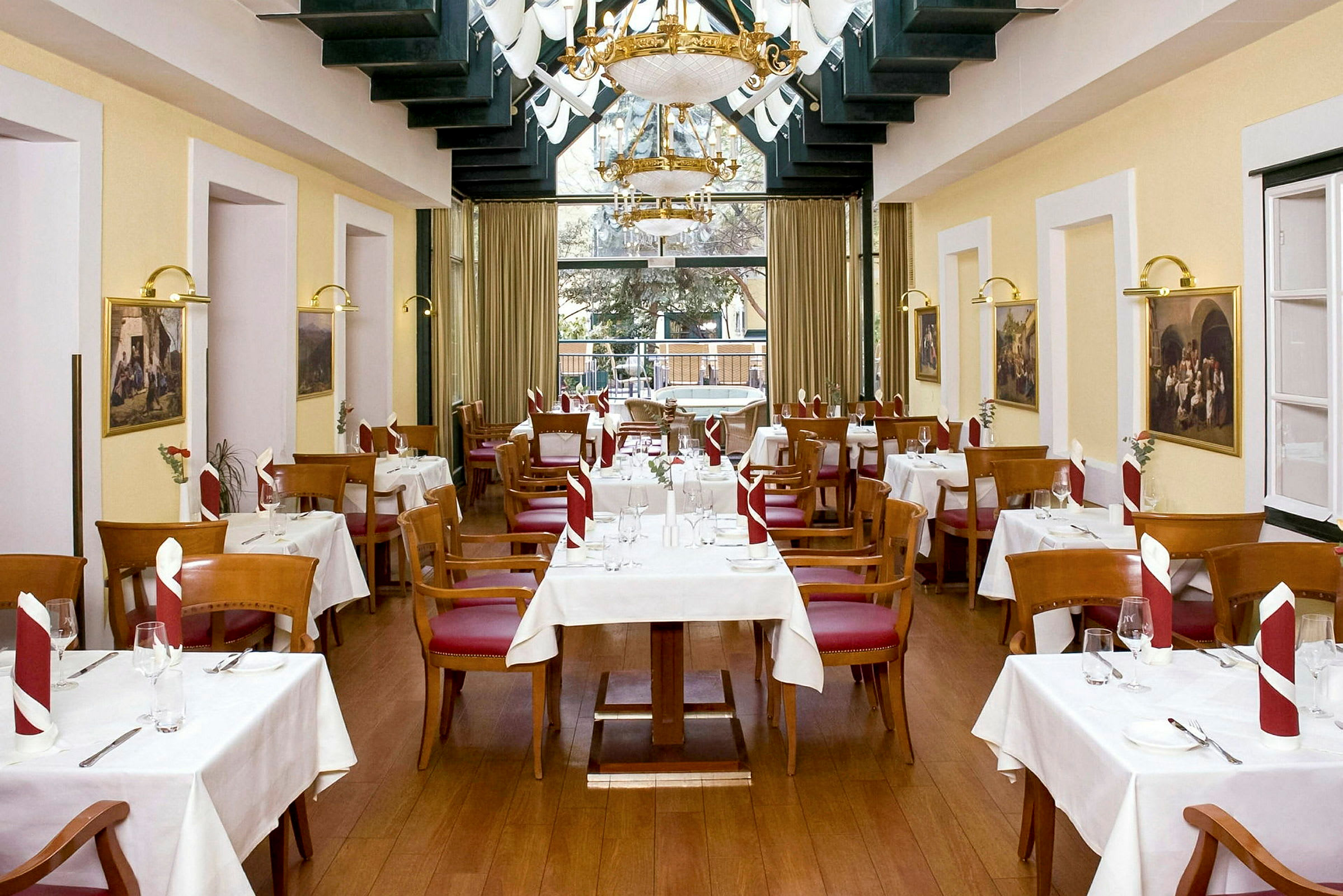 Restaurant med hvite duker på bordene, trestoler med røde seter og pent brettede servietter. (AI-generert tekst)