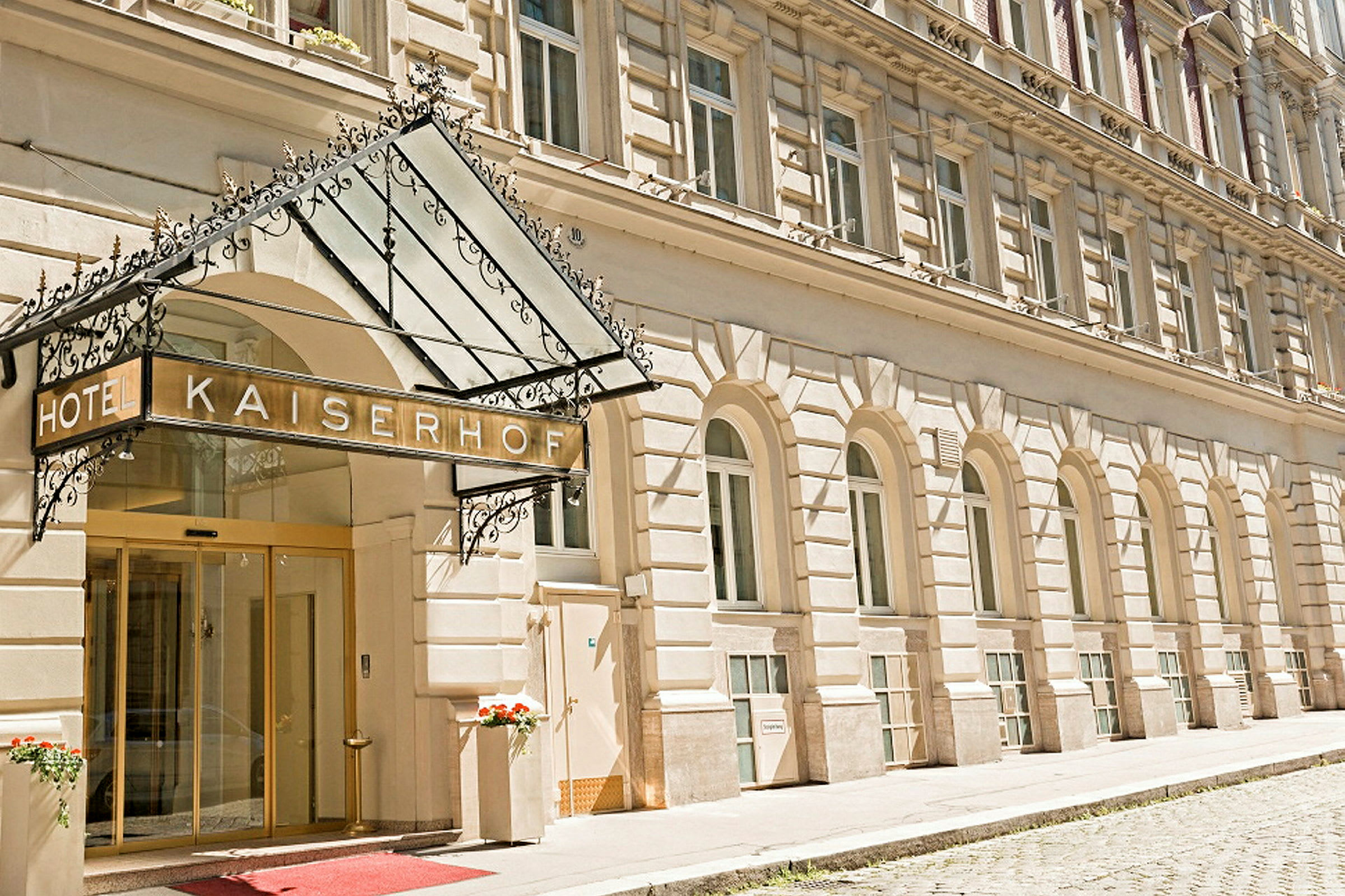 Hotellbygning med inngang og skilt som lyder "Hotel Kaiserhof". (AI-generert tekst)
