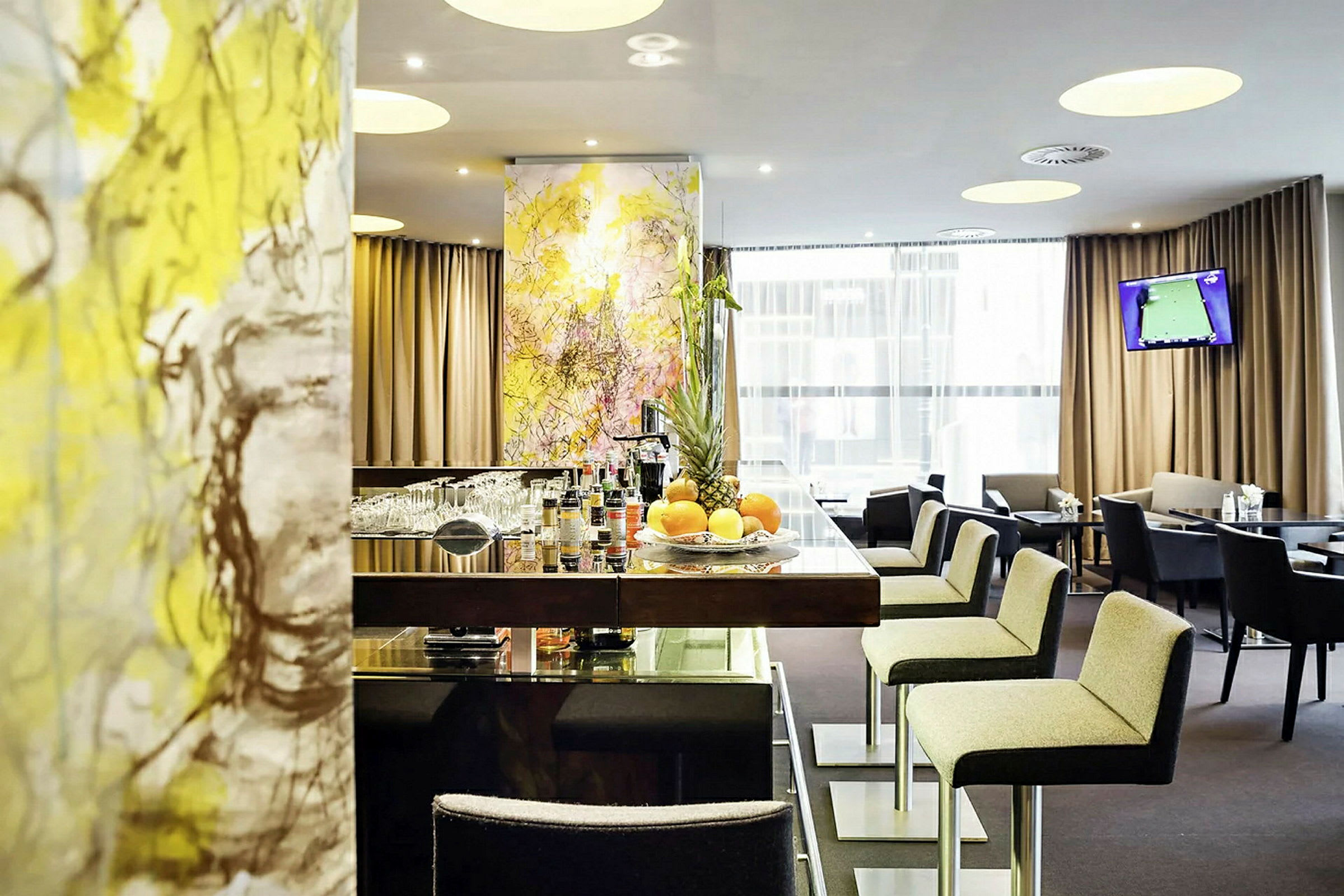 En hotellbar med stilig innredning og moderne møbler. Bord og stoler er tilgjengelige for gjestene. (AI-generert tekst)