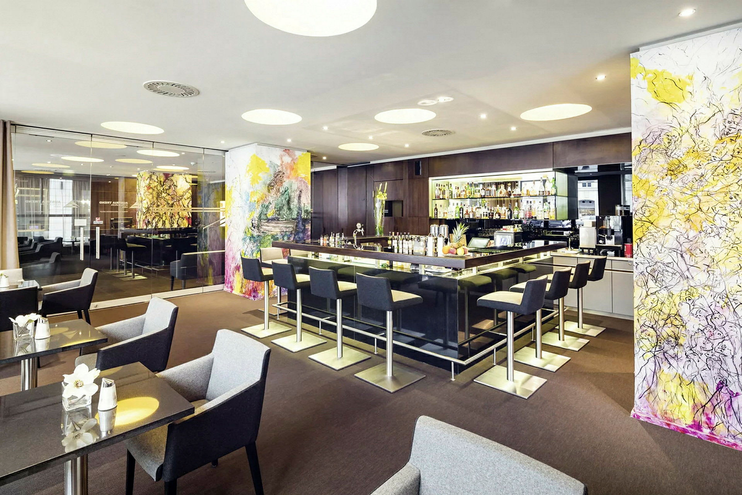 En moderne bar med sitteplasser og fargerike veggdekorasjoner. (AI-generert tekst)