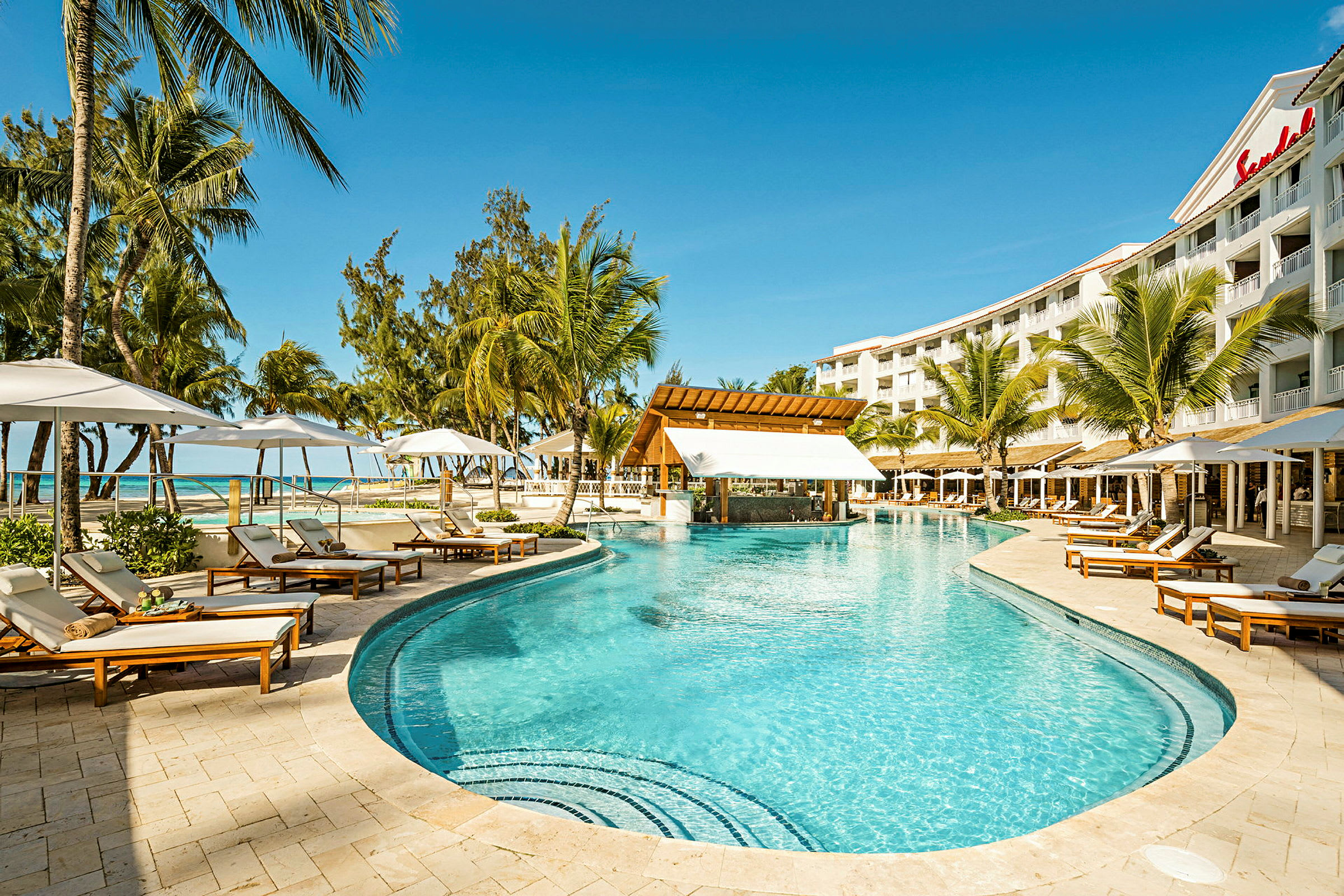 Bassengområde ved Sandals-hotell med solsenger og palmer. (AI-generert tekst)